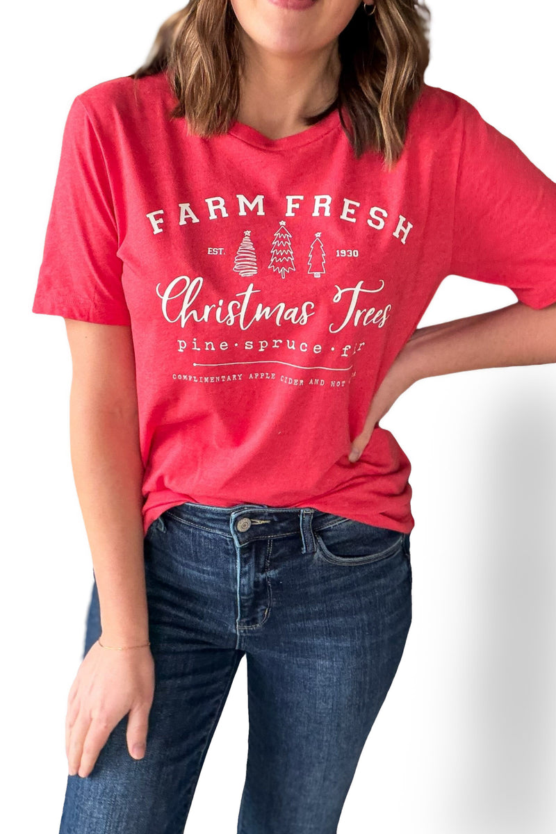 Person wearing a red 'Farm Fresh Christmas Trees' t-shirt on a white background
