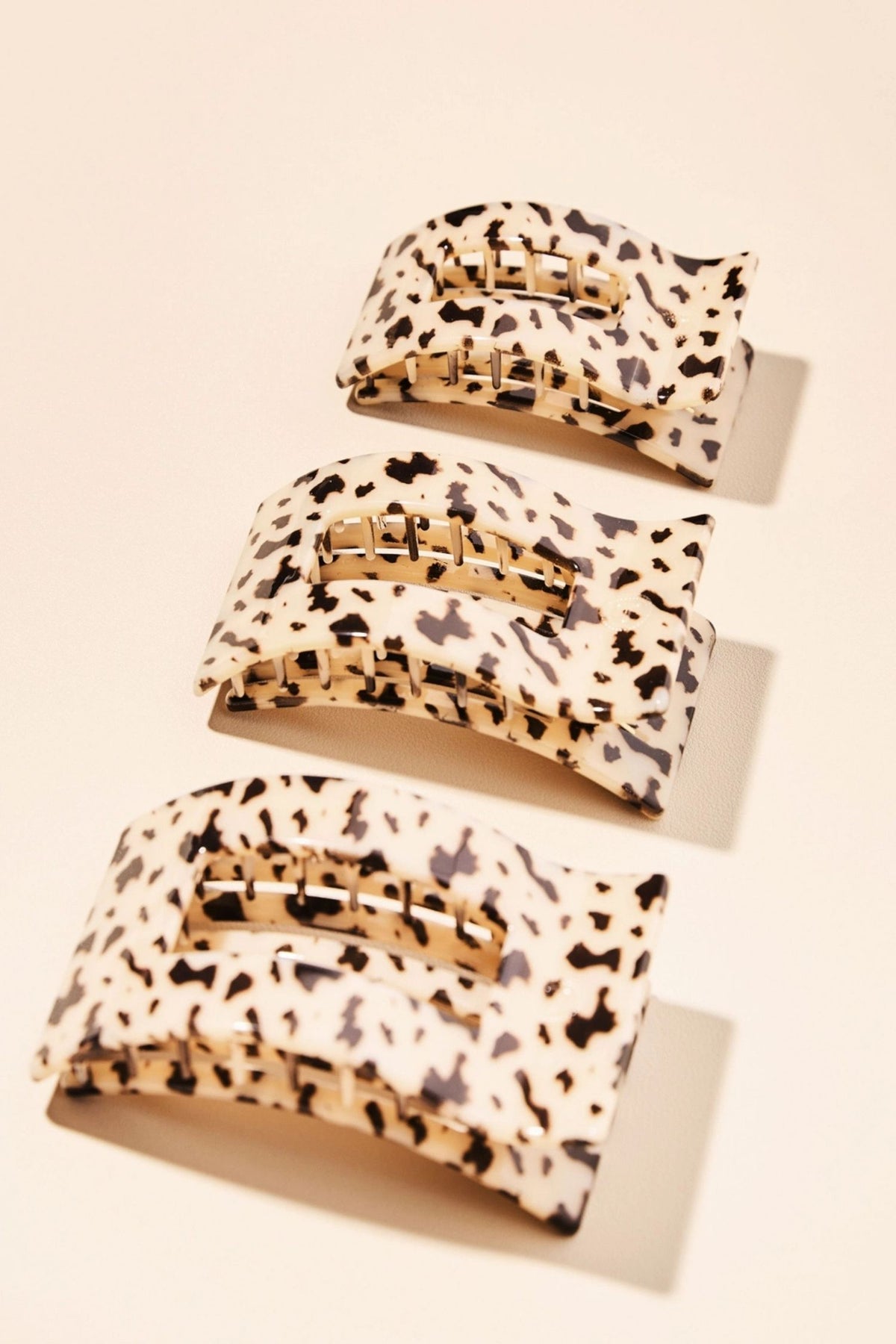 Set of four tortoise print hair clips on a beige background