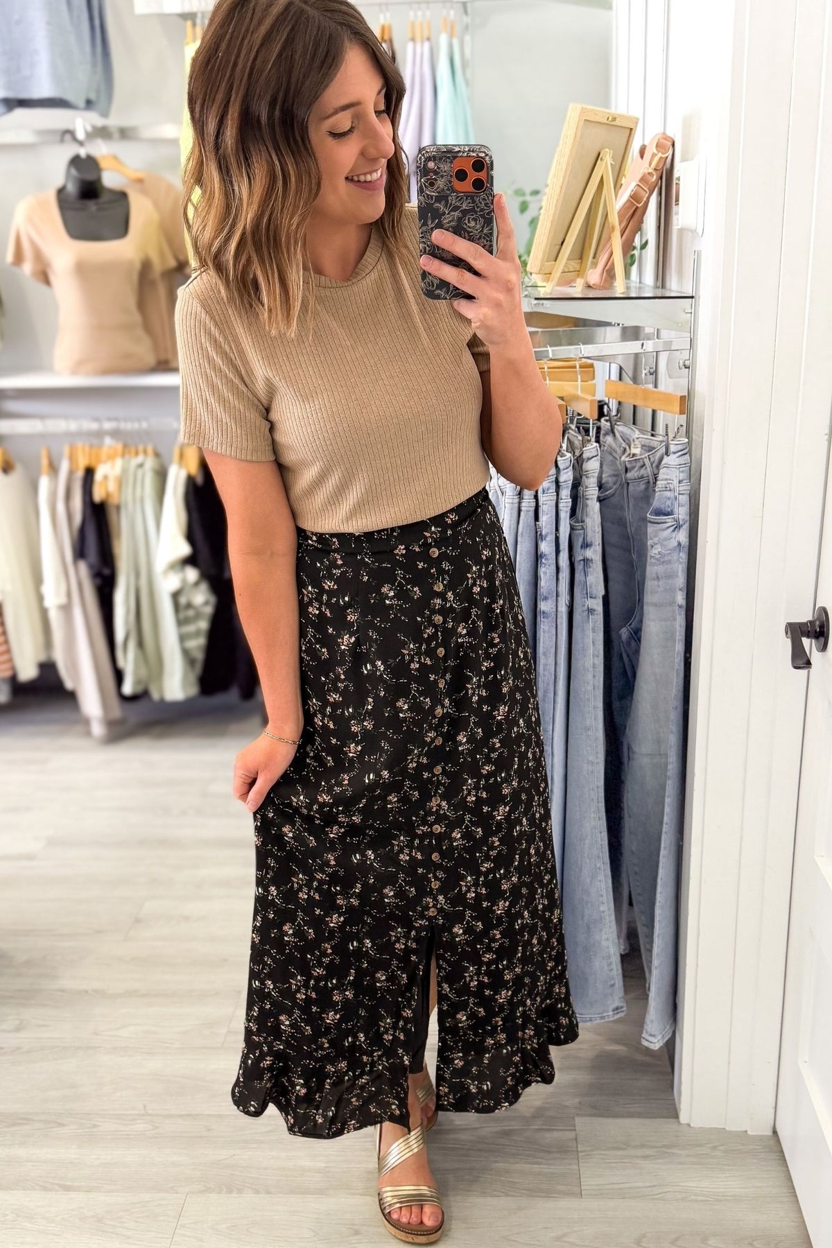 Women taking a selfie in a boutique wearing a floral maxi skirt with button front detail and a neutral top