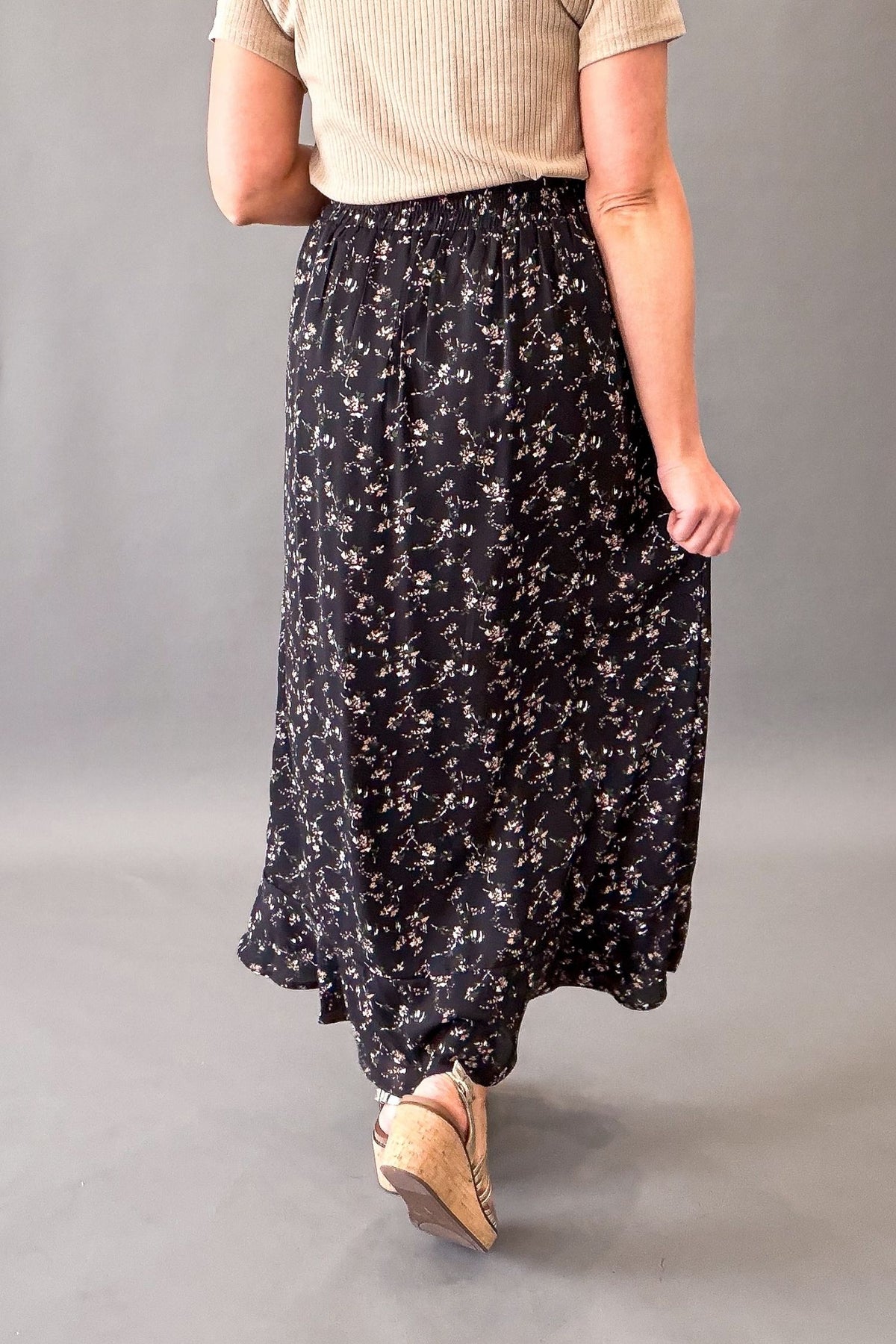 woman wearing a black floral maxi skirt showing the back details