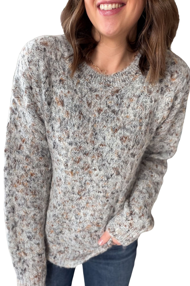 Woman wearing a patterned sweater on a plain background