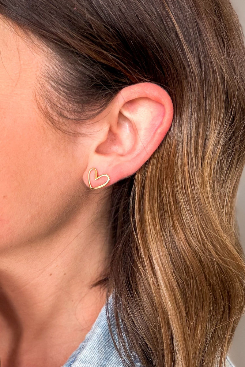 Close-up of dainty gold heart stud earrings with 18K gold plated design and silver post, minimalist everyday jewelry