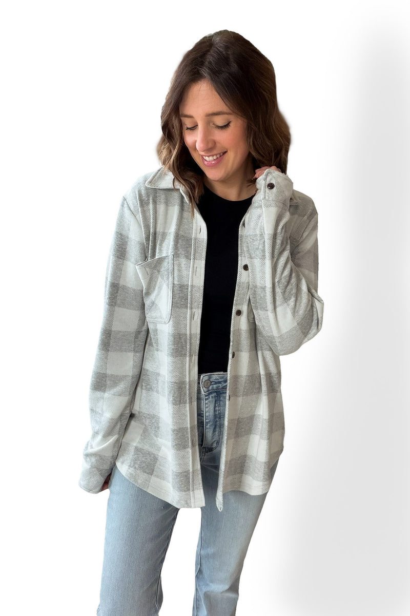 Woman wearing a plaid shirt and jeans on a white background