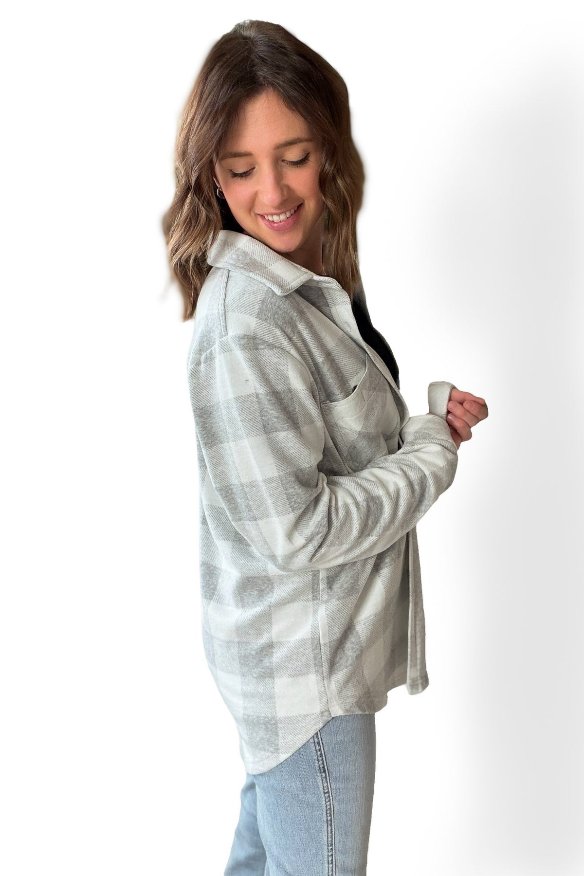 Woman wearing a plaid button up and jeans on a white background