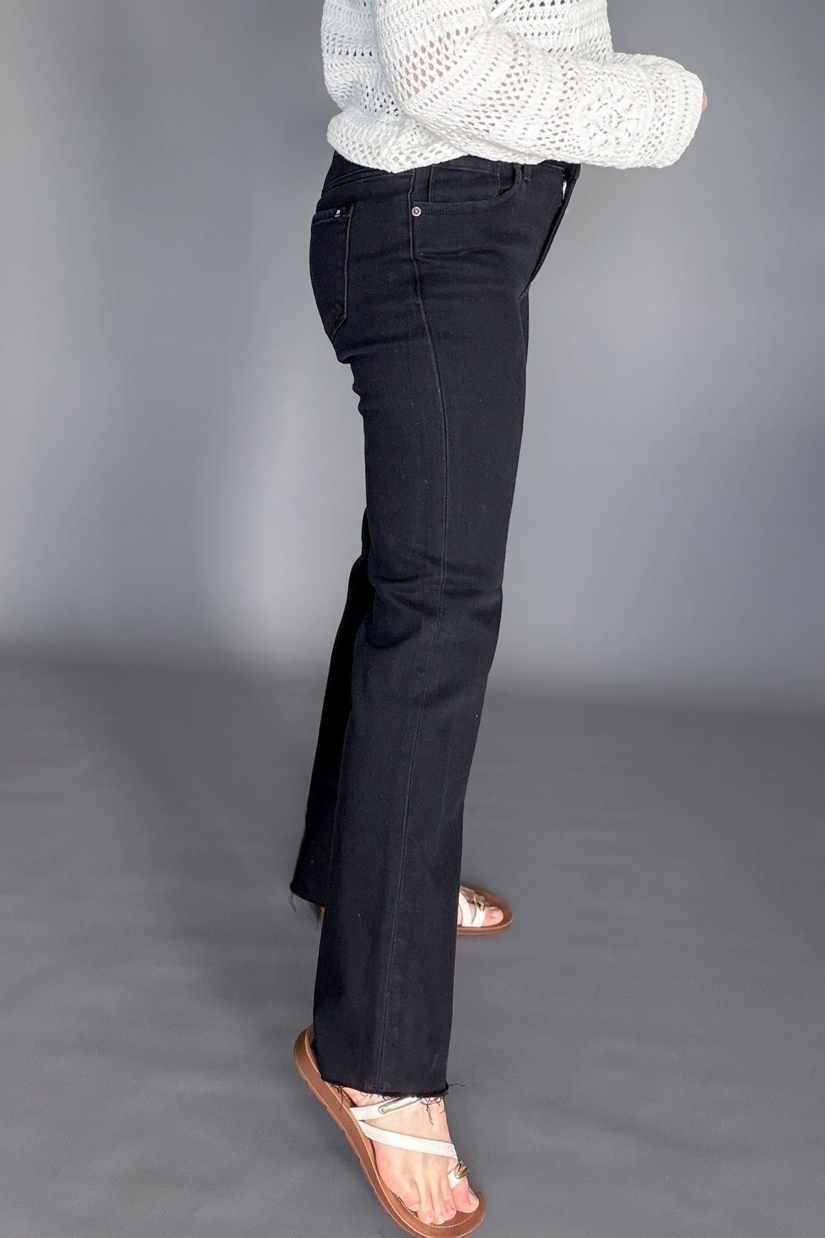 High rise black bootcut jeans styled with a sweater and sandals