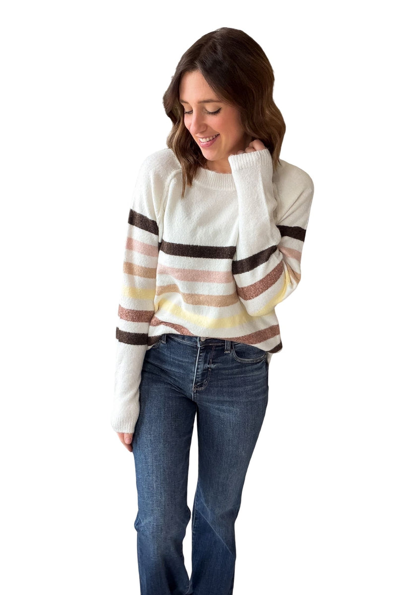 Woman wearing a striped sweater and jeans on a white background