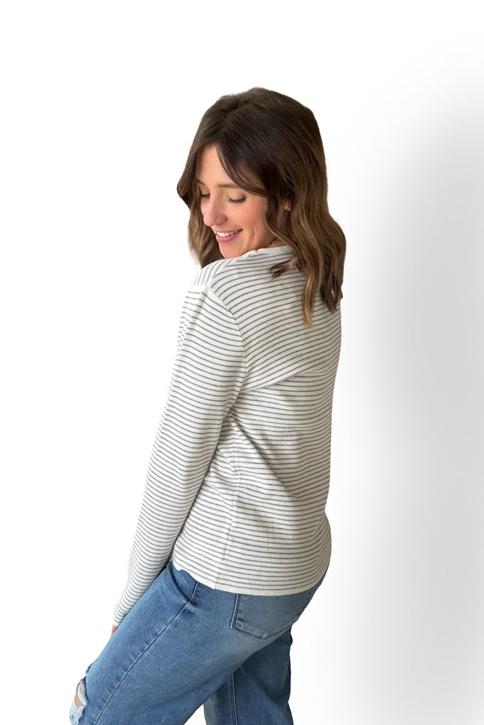 Woman wearing a striped shirt and jeans on a white background