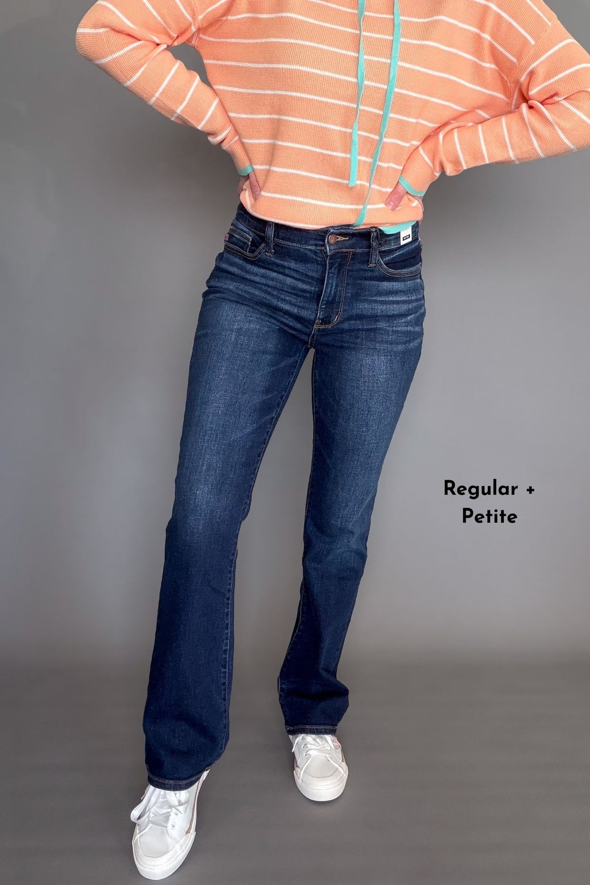 Person wearing blue jeans with a gray background