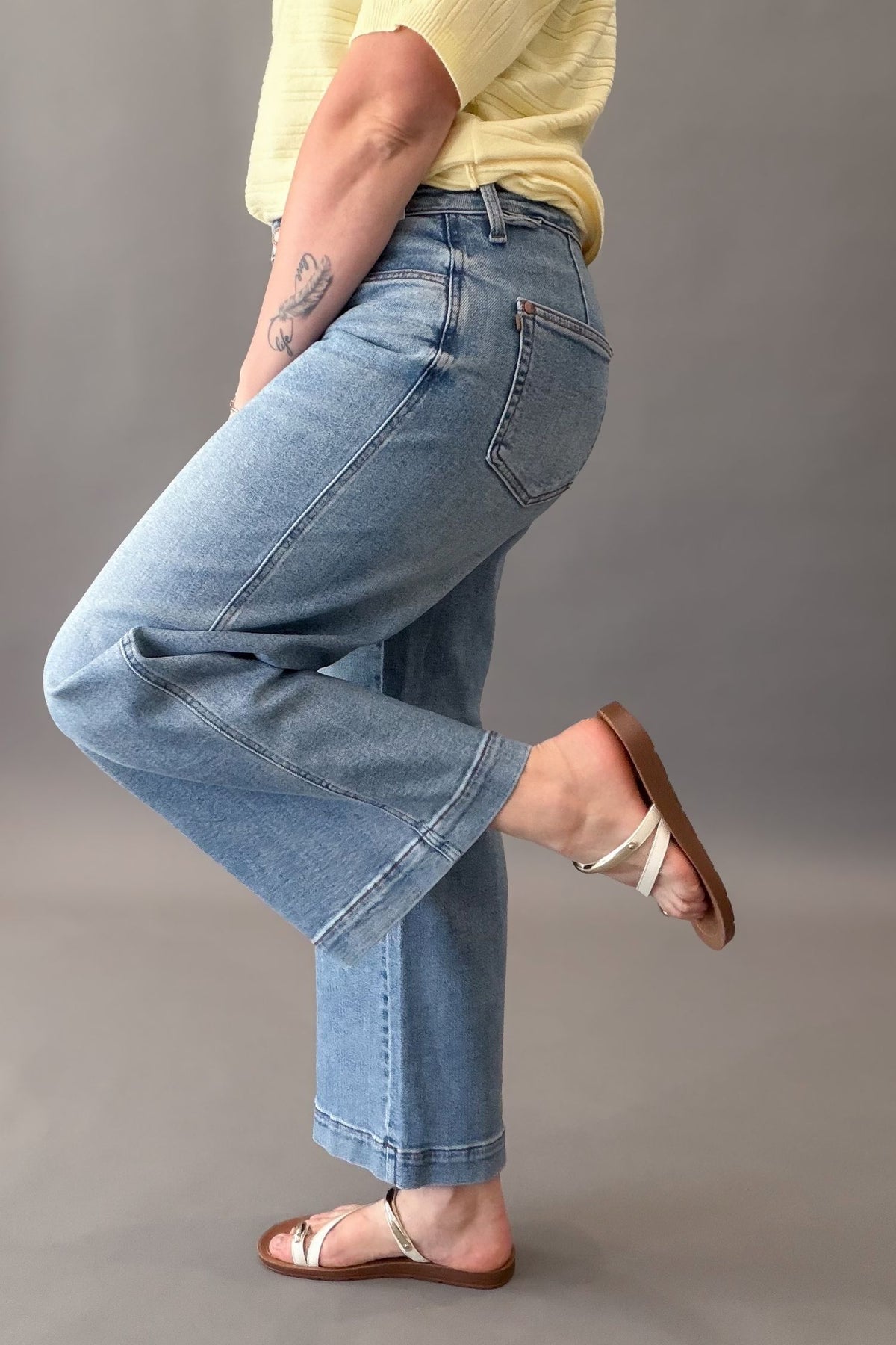 woman wearing a pair of mid rise judy blue wide leg jeans showing the finished hem details