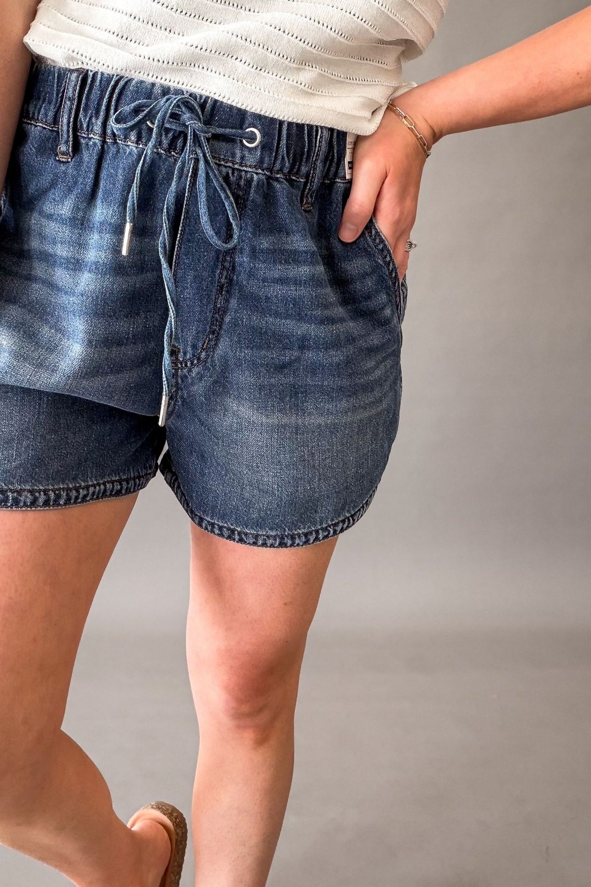 Woman wearing Judy Blue high waist boxer shorts with drawstring waist and pockets, lightweight soft denim shorts for women