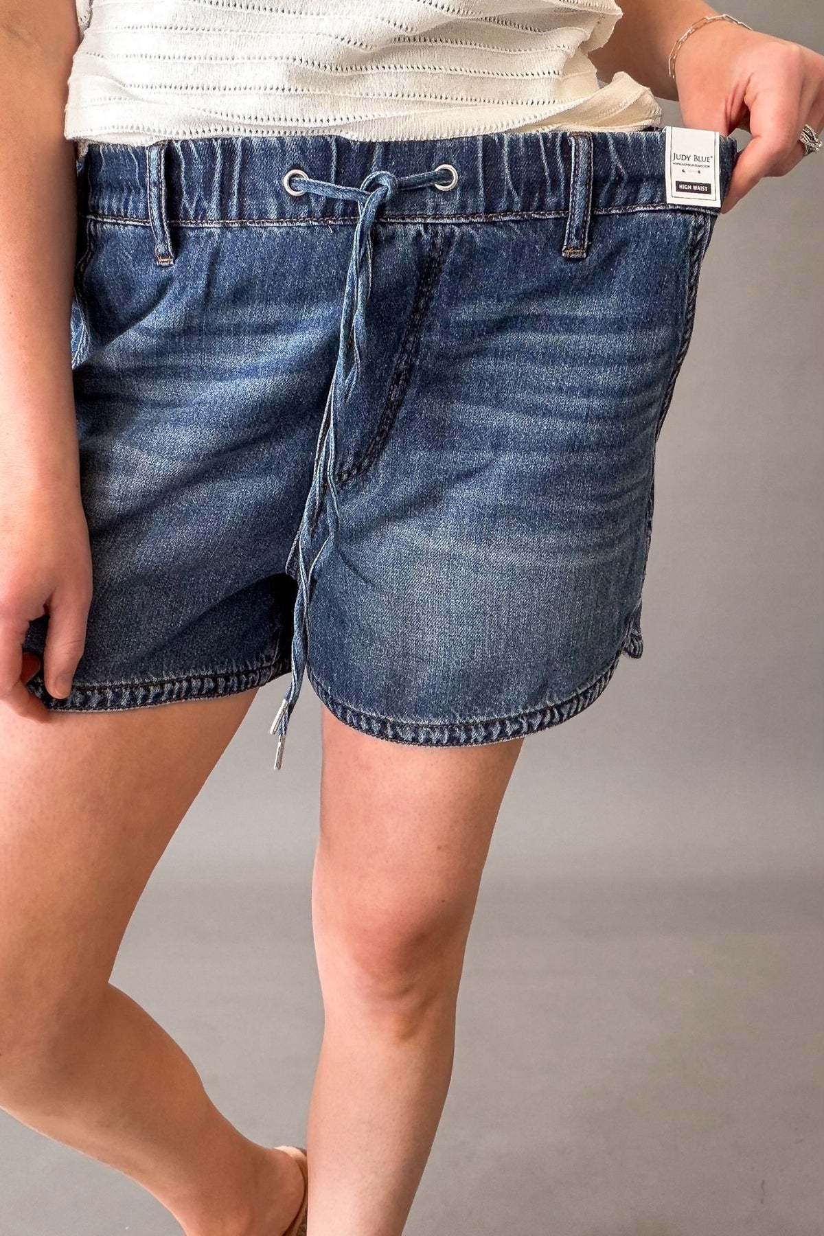 Woman wearing Judy Blue high waist boxer shorts with drawstring waist and an elastic band for a comfortable non-restrictive fit.