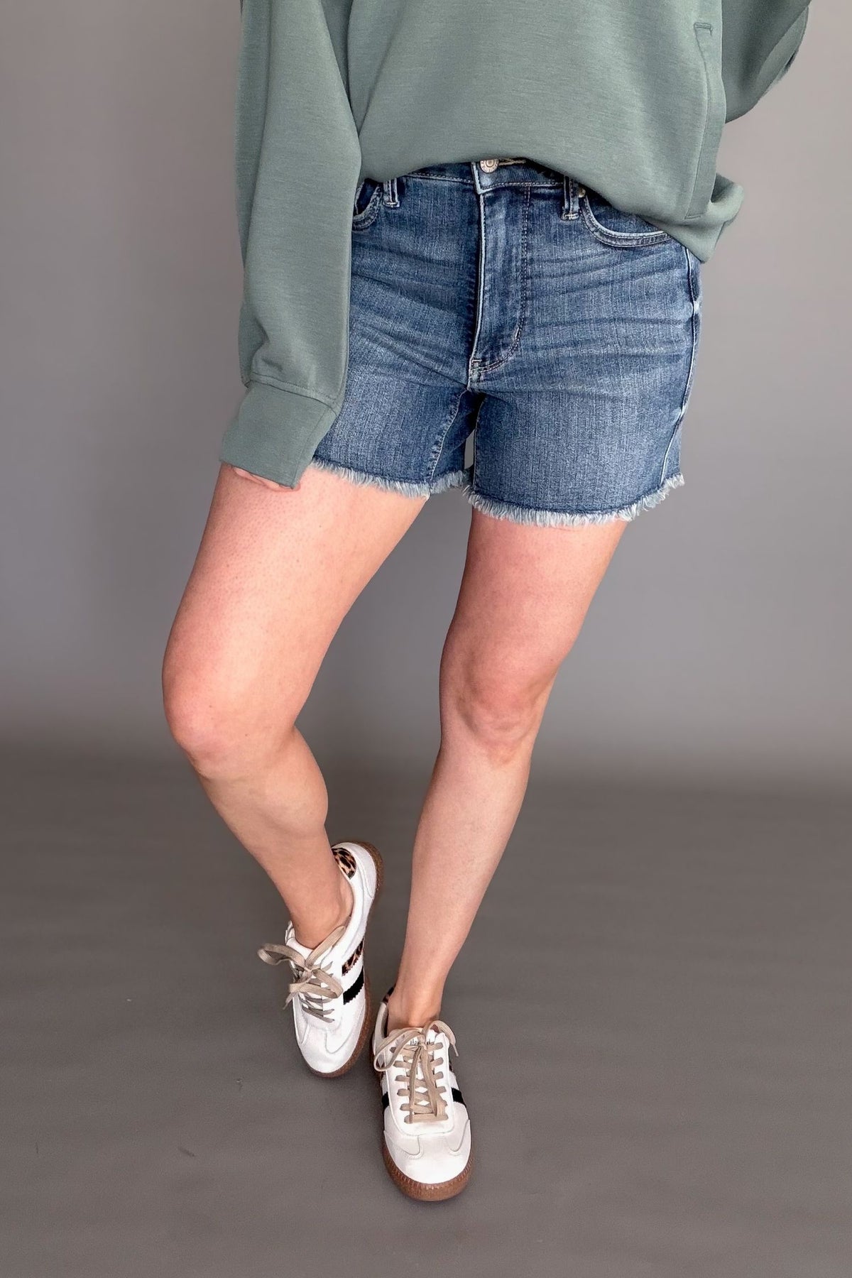 Judy Blue high waist tummy control fray hem denim shorts on model with casual sneakers