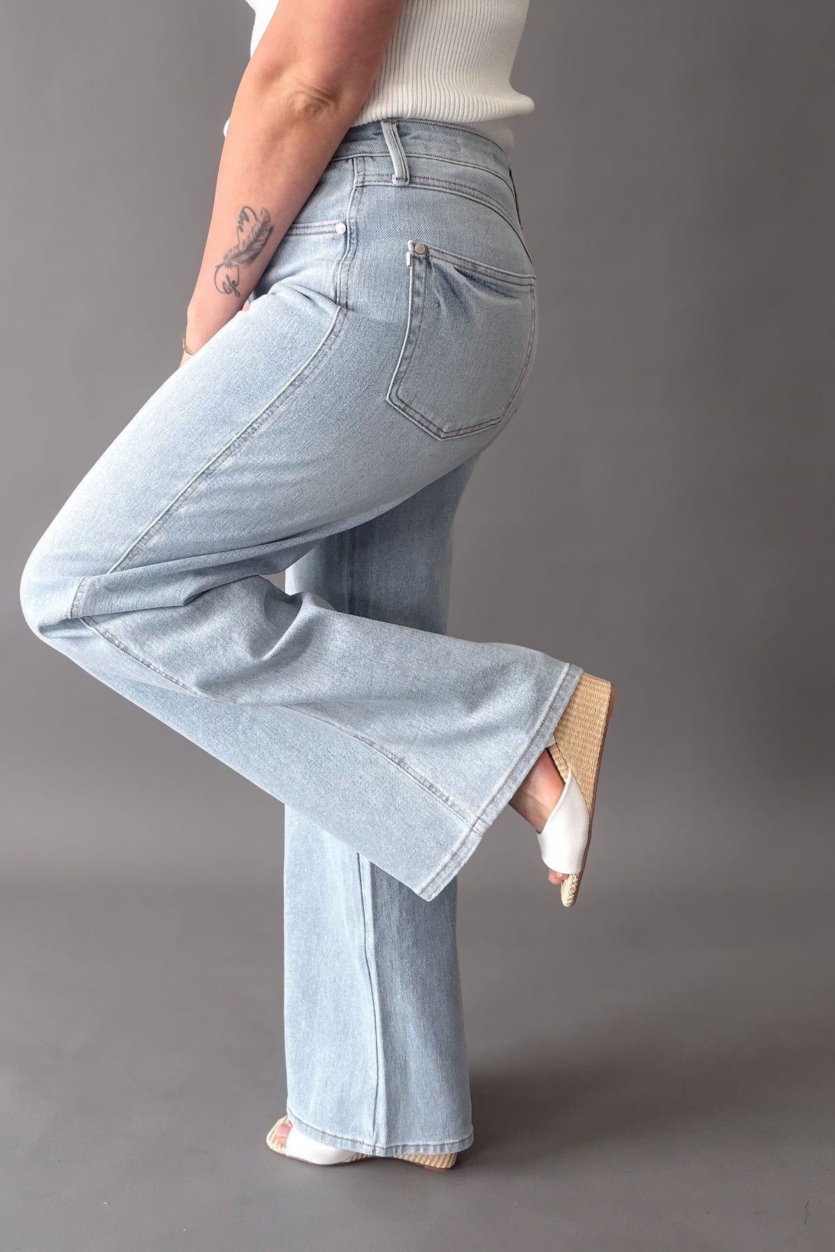 Woman wearing a pair of light wash judy blue jeans showing the side details