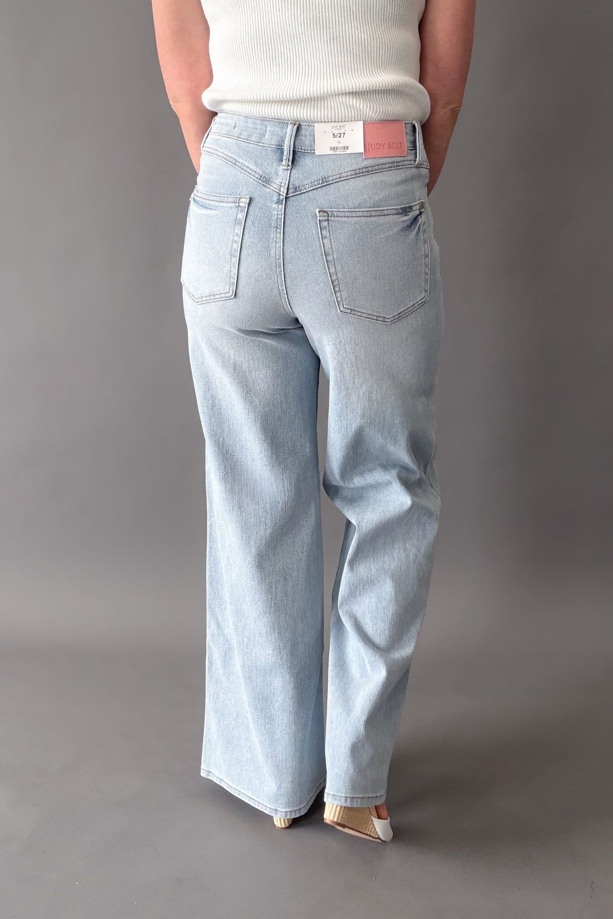 woman wearing a pair of judy blue jeans showing the back pockets, seam detail and lenght.