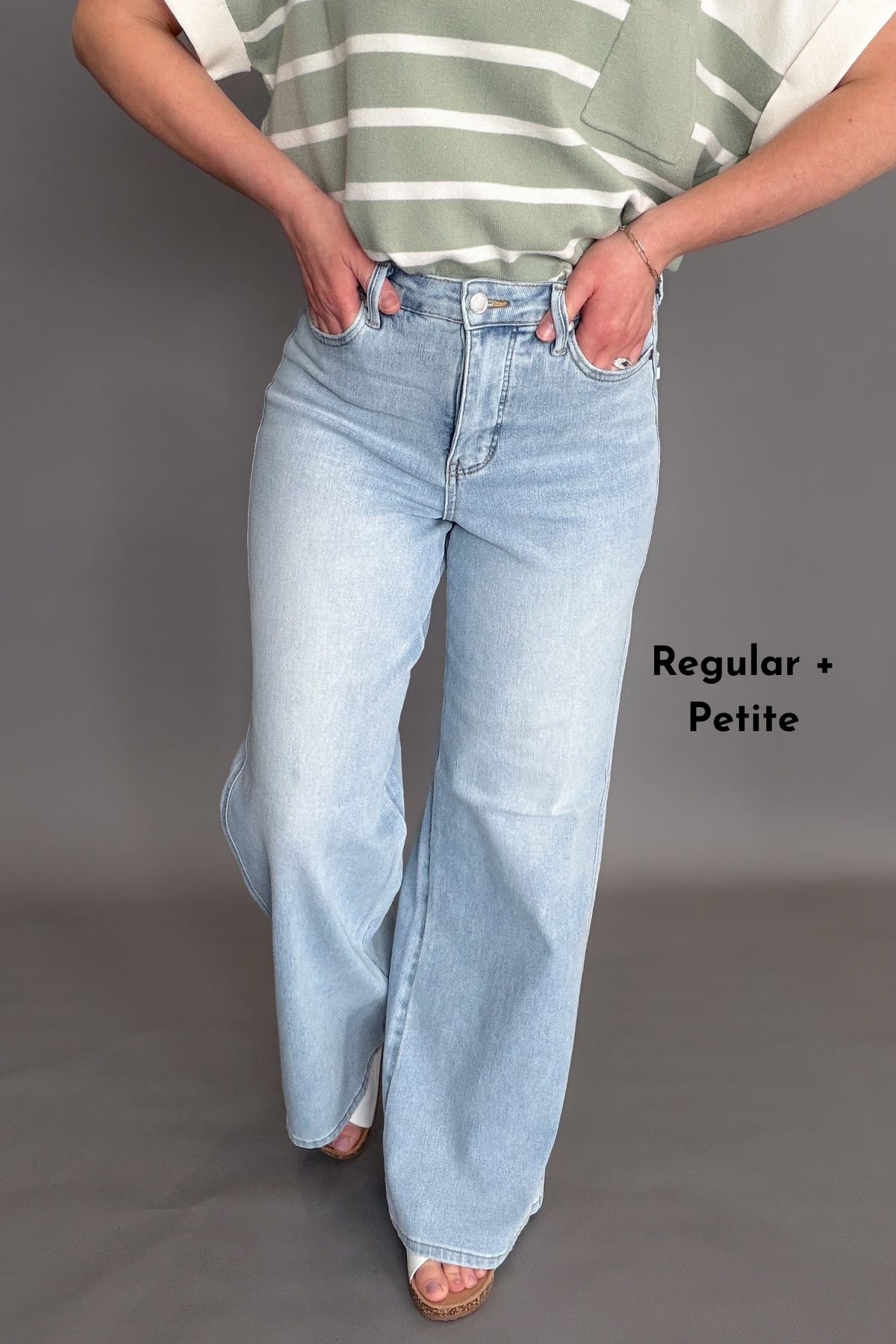 Woman wearing Judy Blue high waist wide leg jeans in a light wash with stretch denim, available in regular and petite inseams