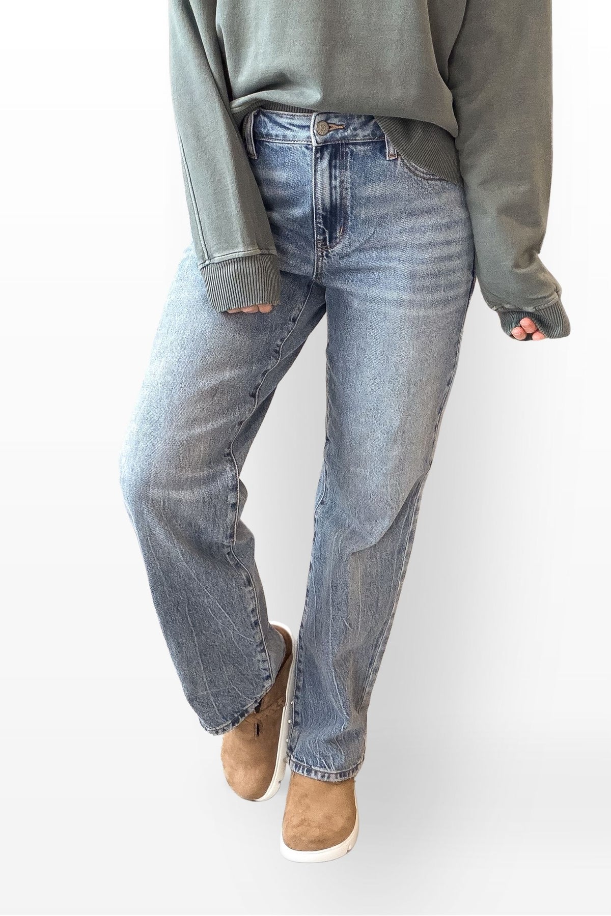 Person wearing a green sweatshirt and blue jeans on a white background