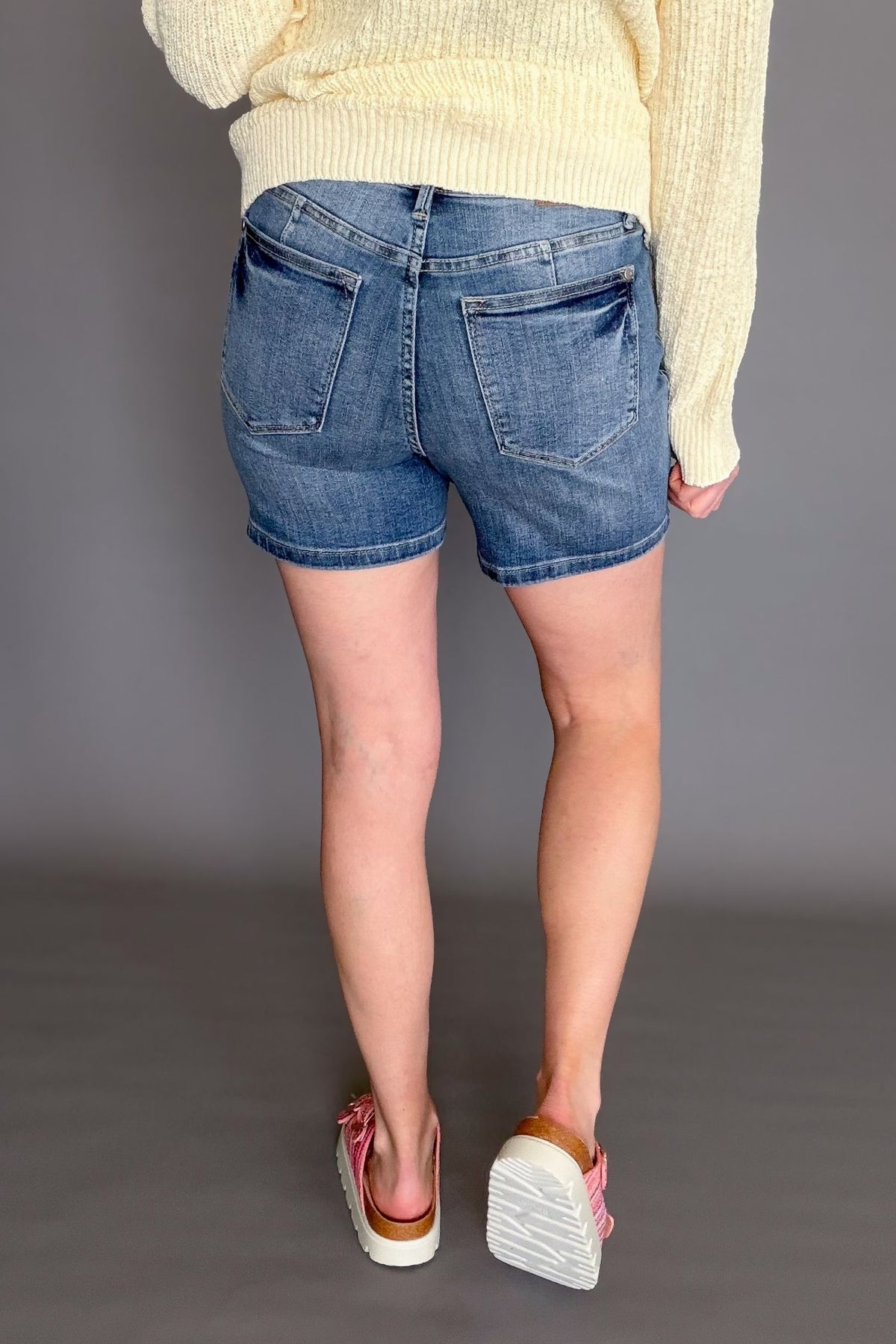Judy Blue mid rise tummy control mid length denim shorts on model