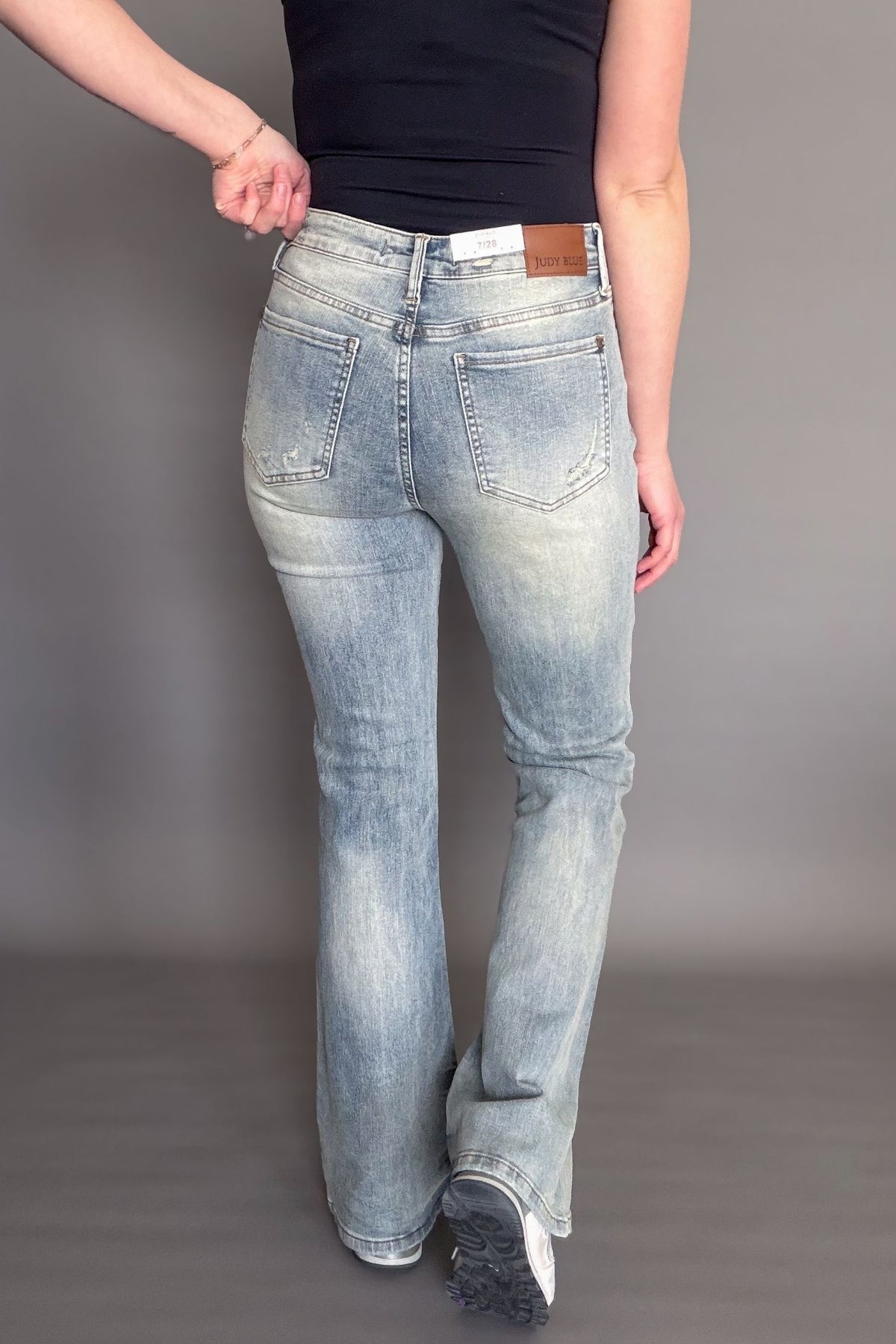 Person wearing light blue jeans on a plain background