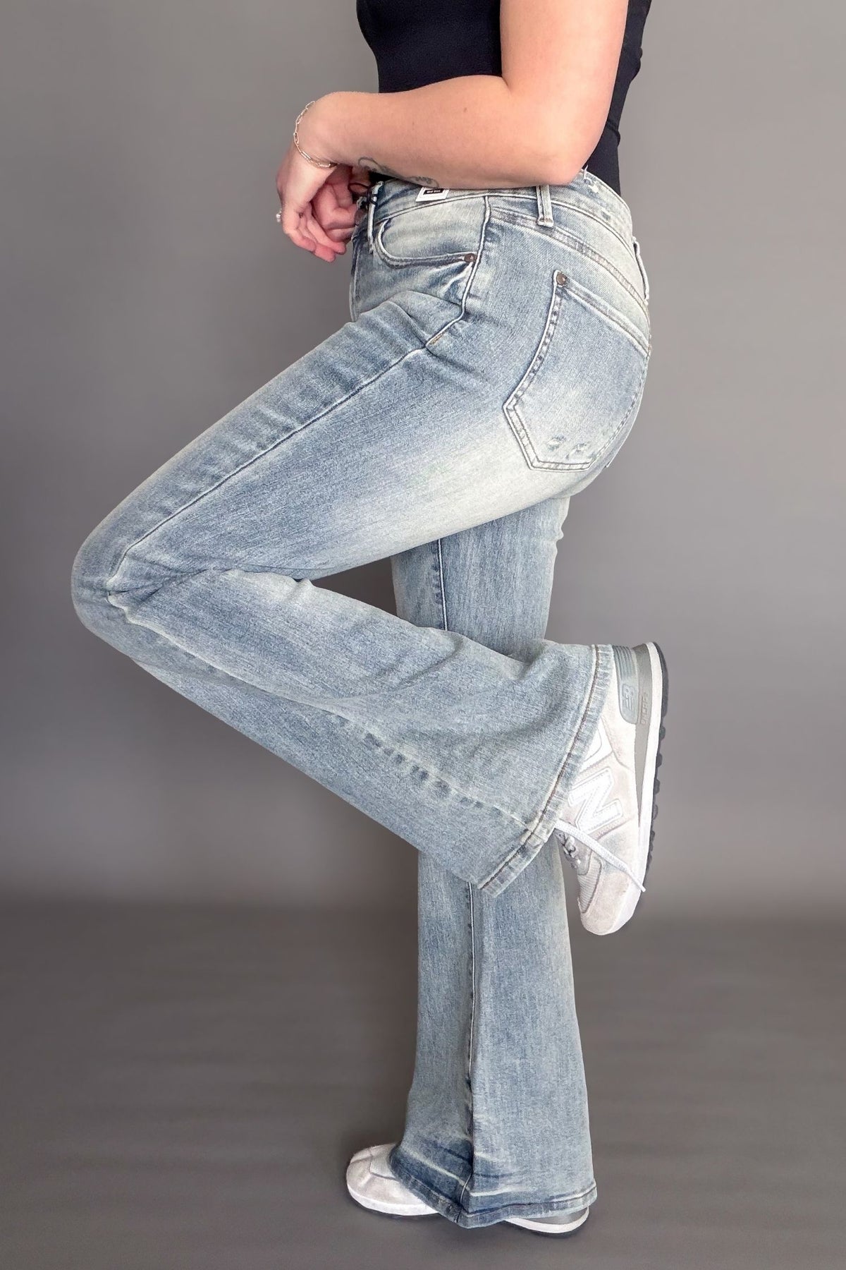 Light blue jeans worn by a person on a gray background