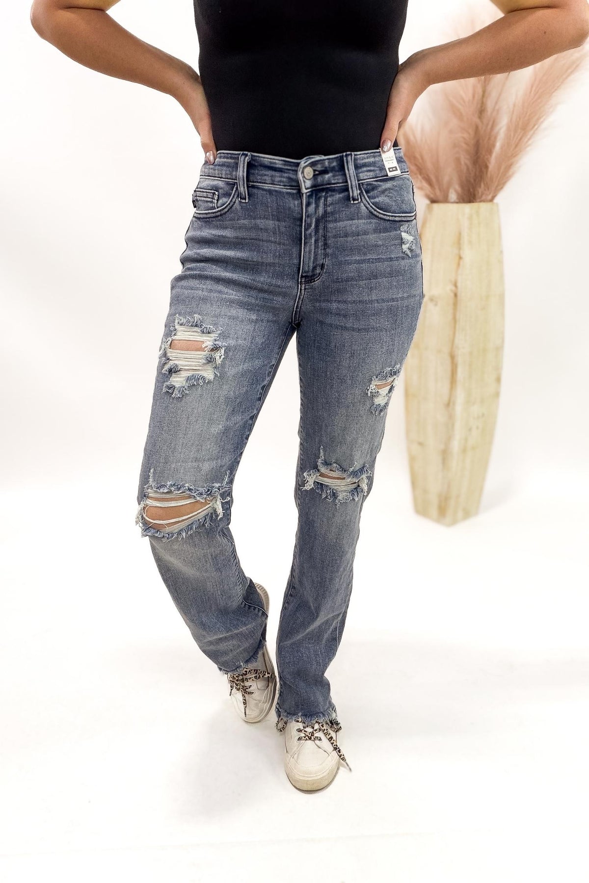 Person wearing distressed Judy Blue jeans on a white background