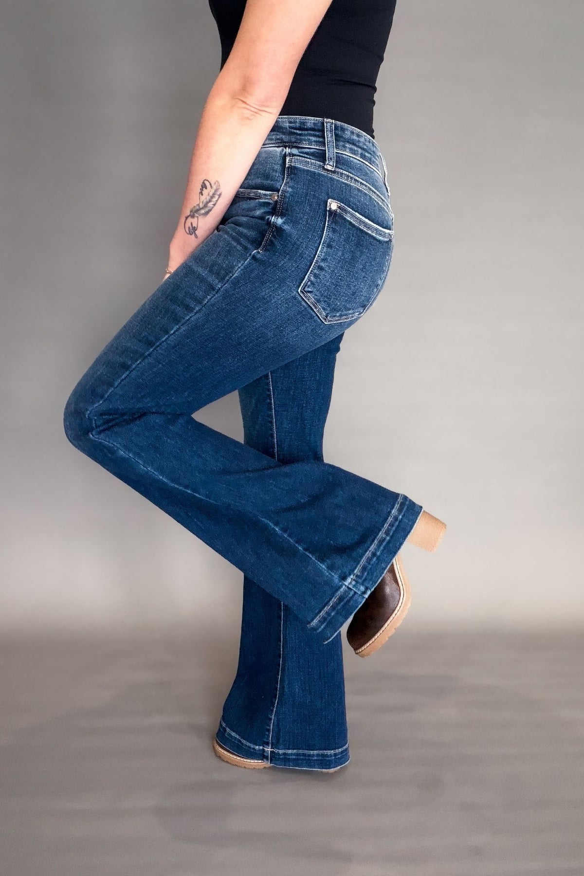Person wearing blue jeans on a gray background
