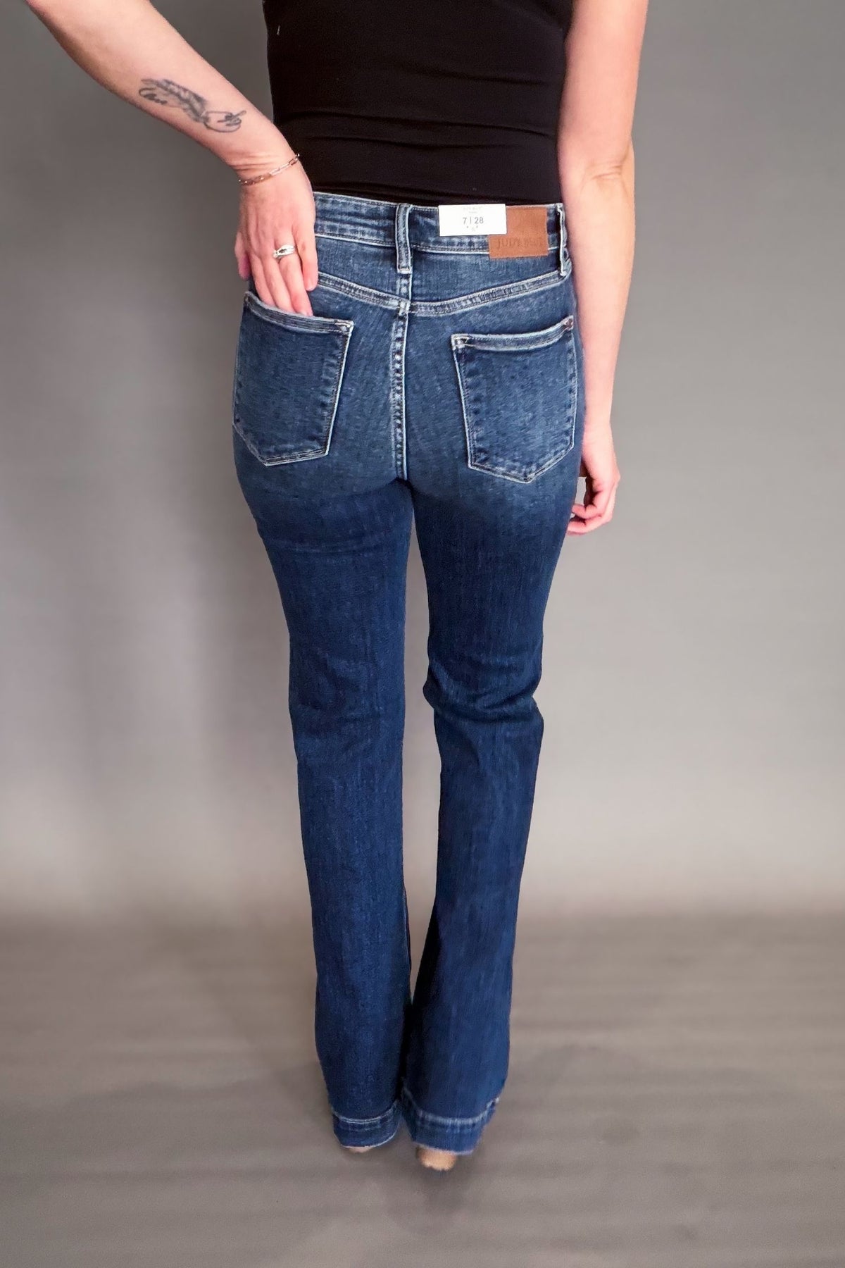 Person wearing blue jeans on a plain background