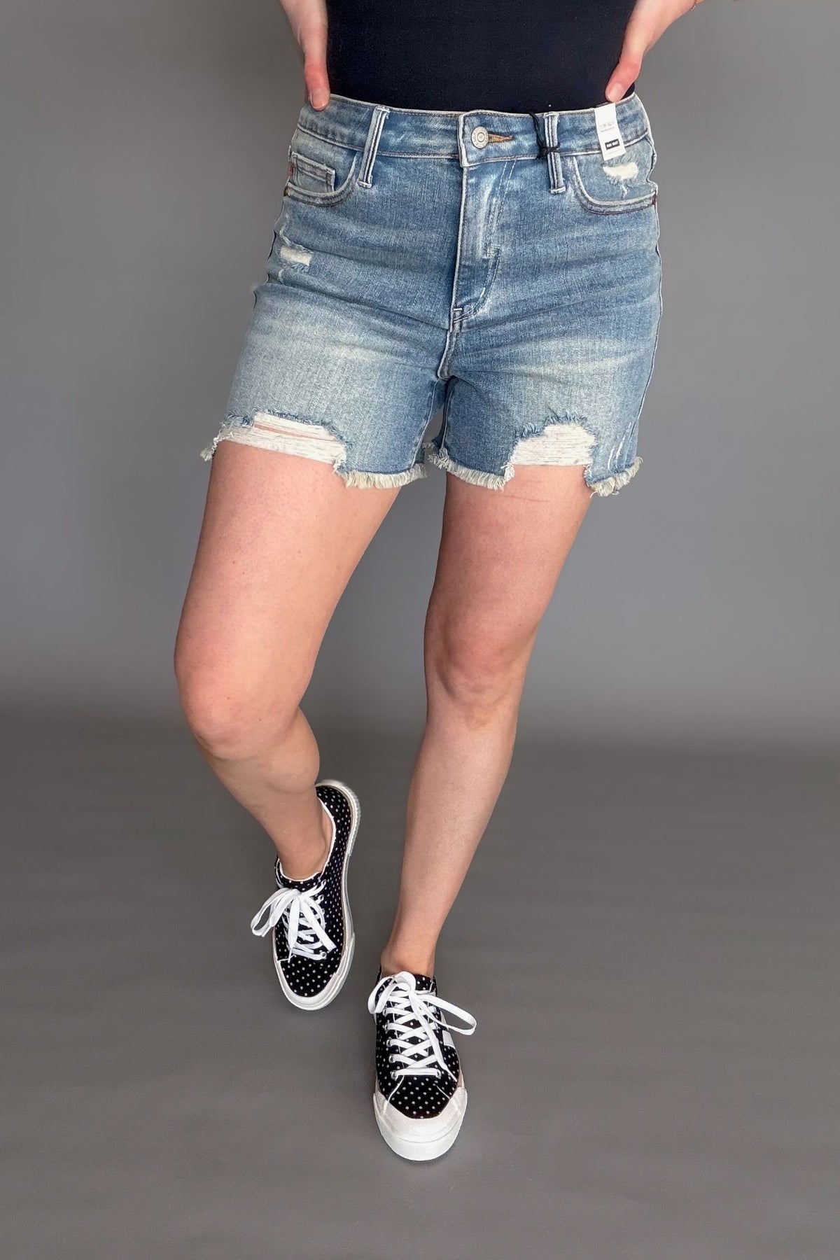Judy Blue Tinley high waist distressed denim shorts on model with frayed hem