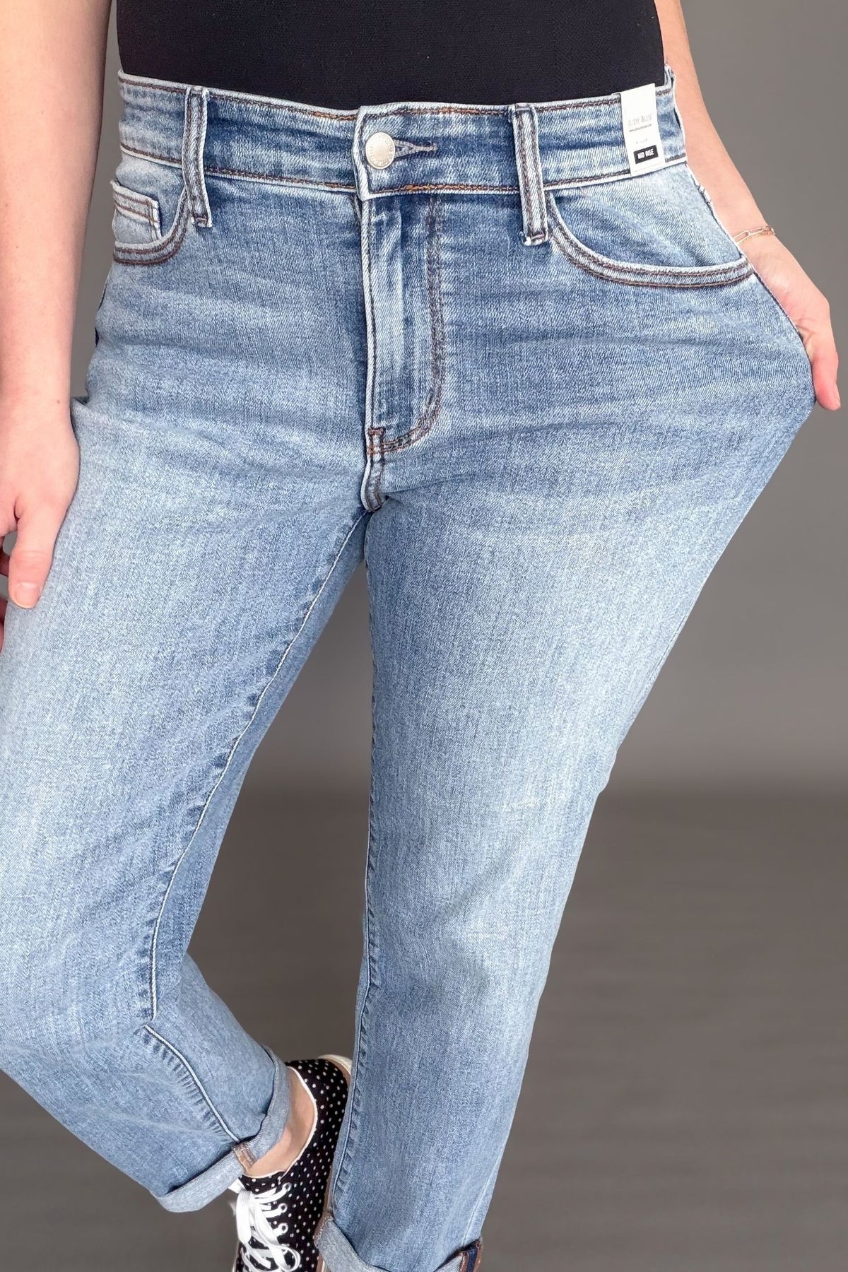 Close up of Judy Blue mid rise boyfriend jeans waistband and light wash stretch denim.