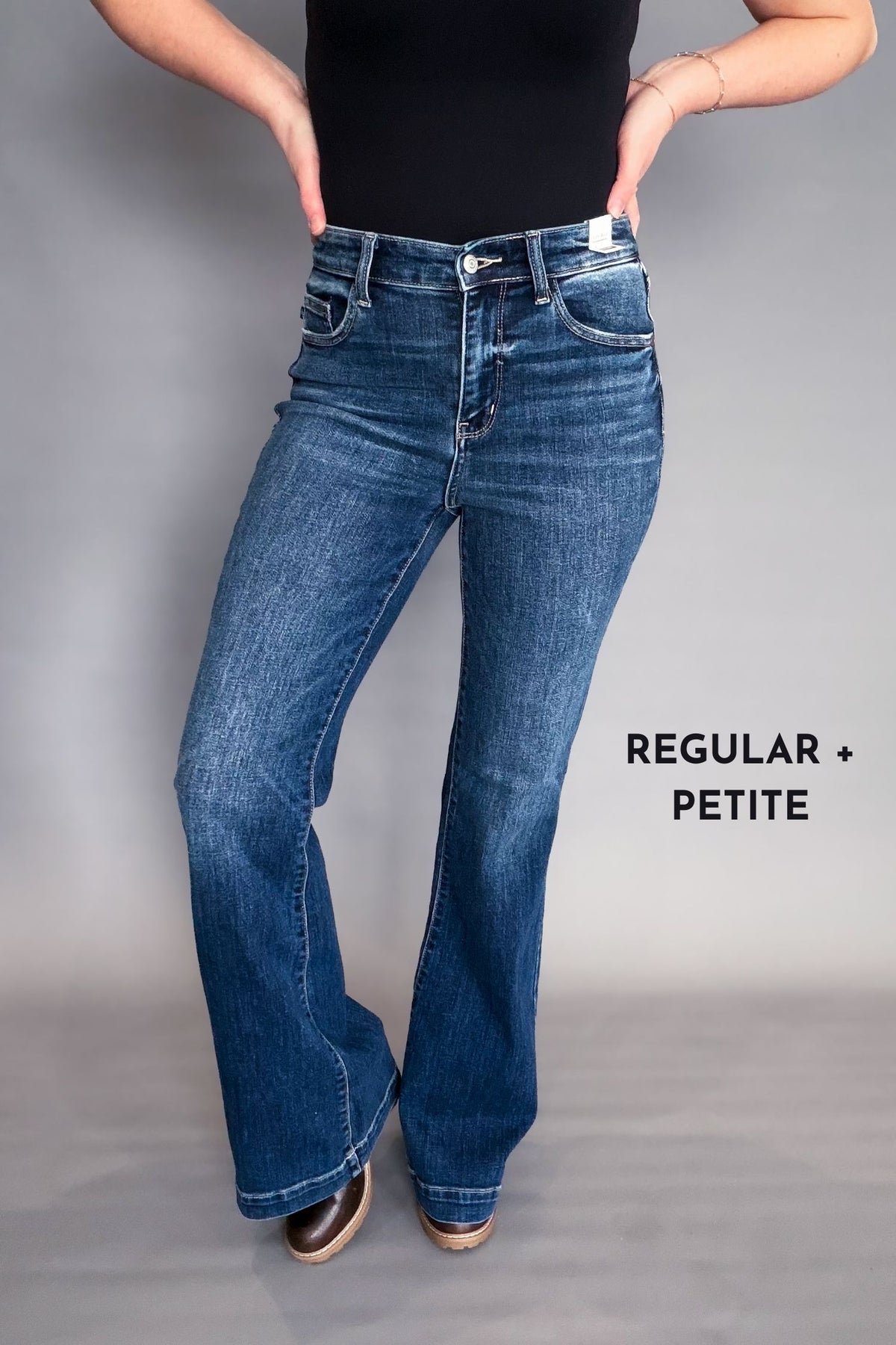 Person wearing blue jeans with 'Regular + Petite' text on a gray background