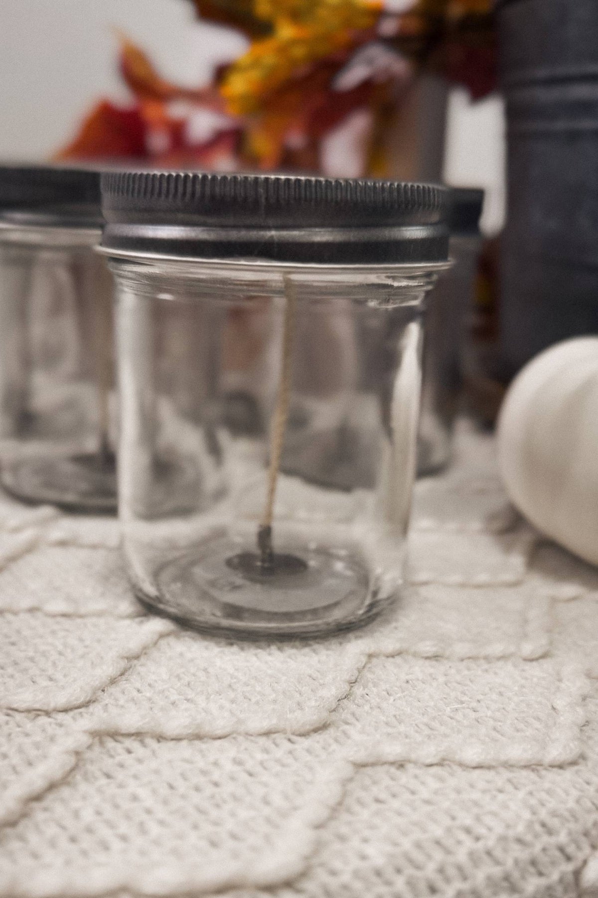 Clear glass jar with a black lid on a textured surface