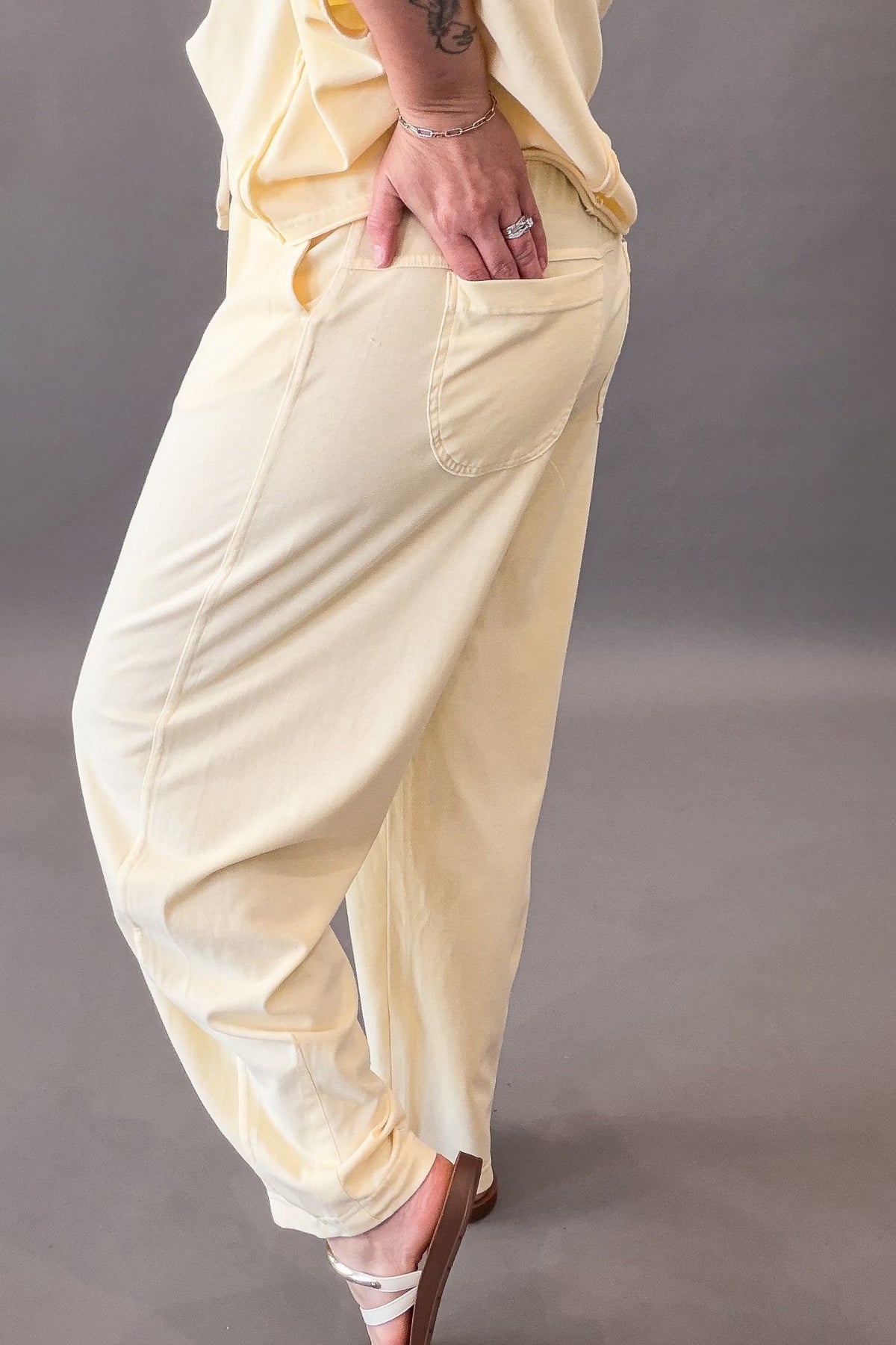 Person wearing light yellow lounge pants against a plain background