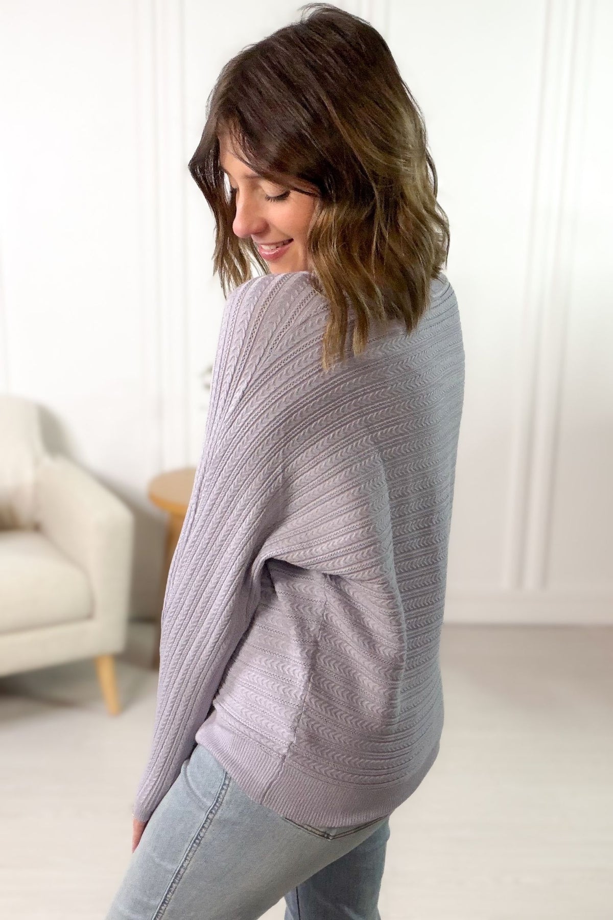 Women's lilac braided pointelle sweater with textured knit styled with light wash denim showing the back/side