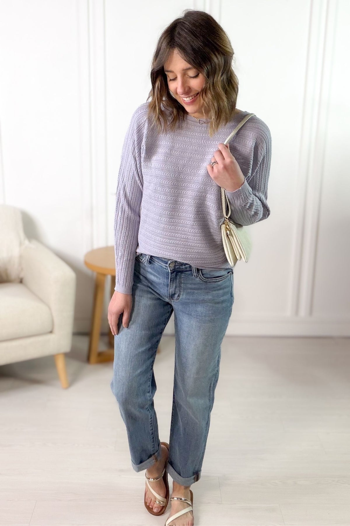 Women's lilac braided pointelle sweater with textured knit styled with medium wash denim, sandals and a handbag.