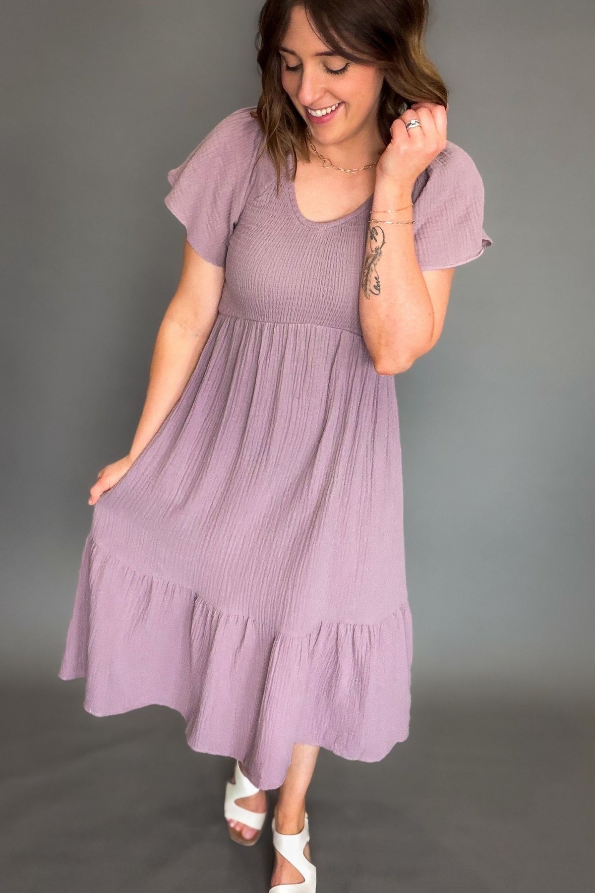 Woman wearing a purple dress against a gray background