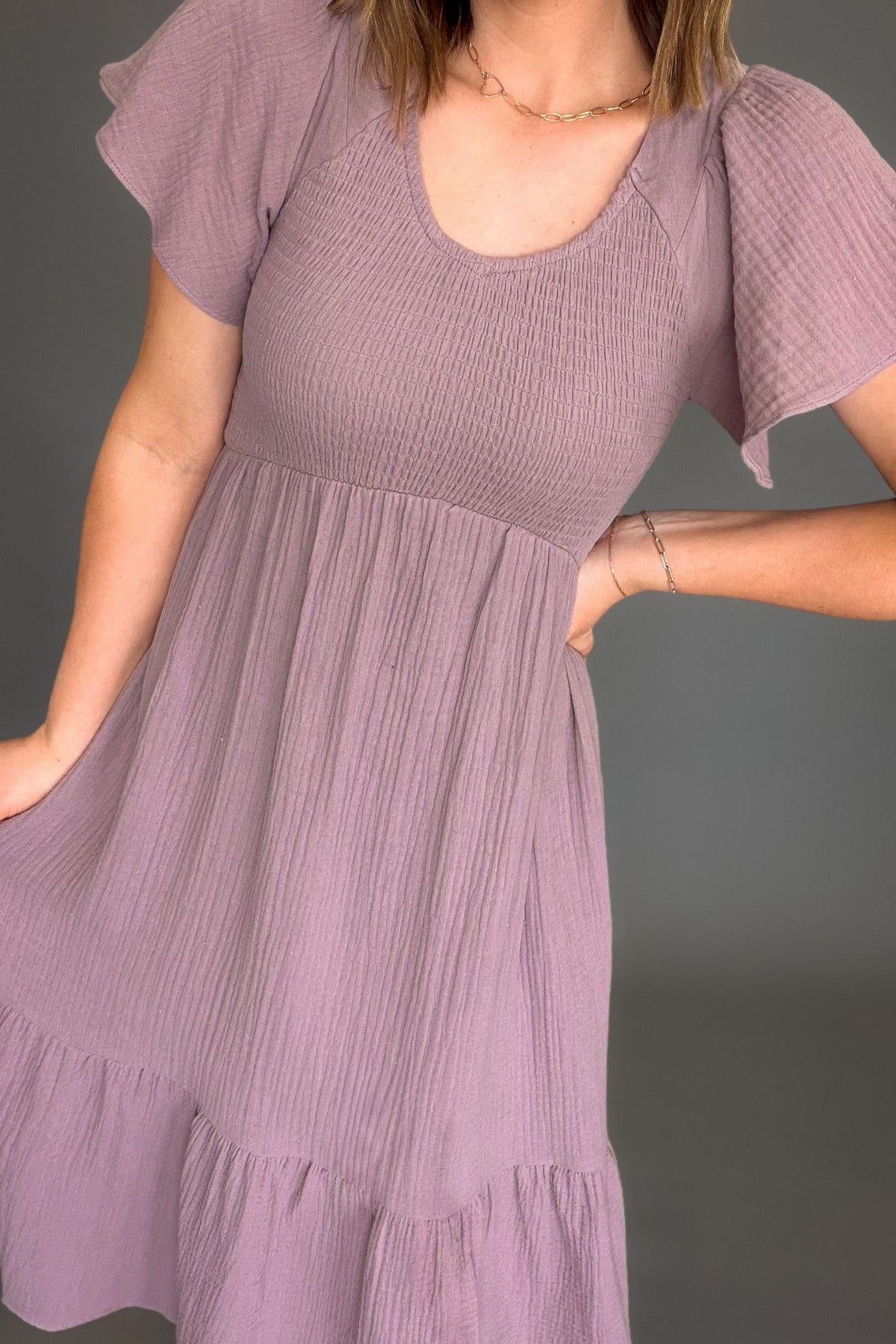 Woman wearing a purple dress against a gray background