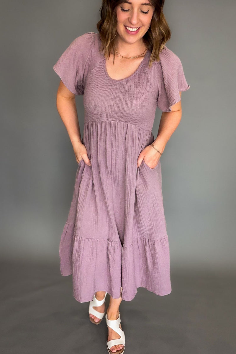 Woman wearing a purple dress against a gray background