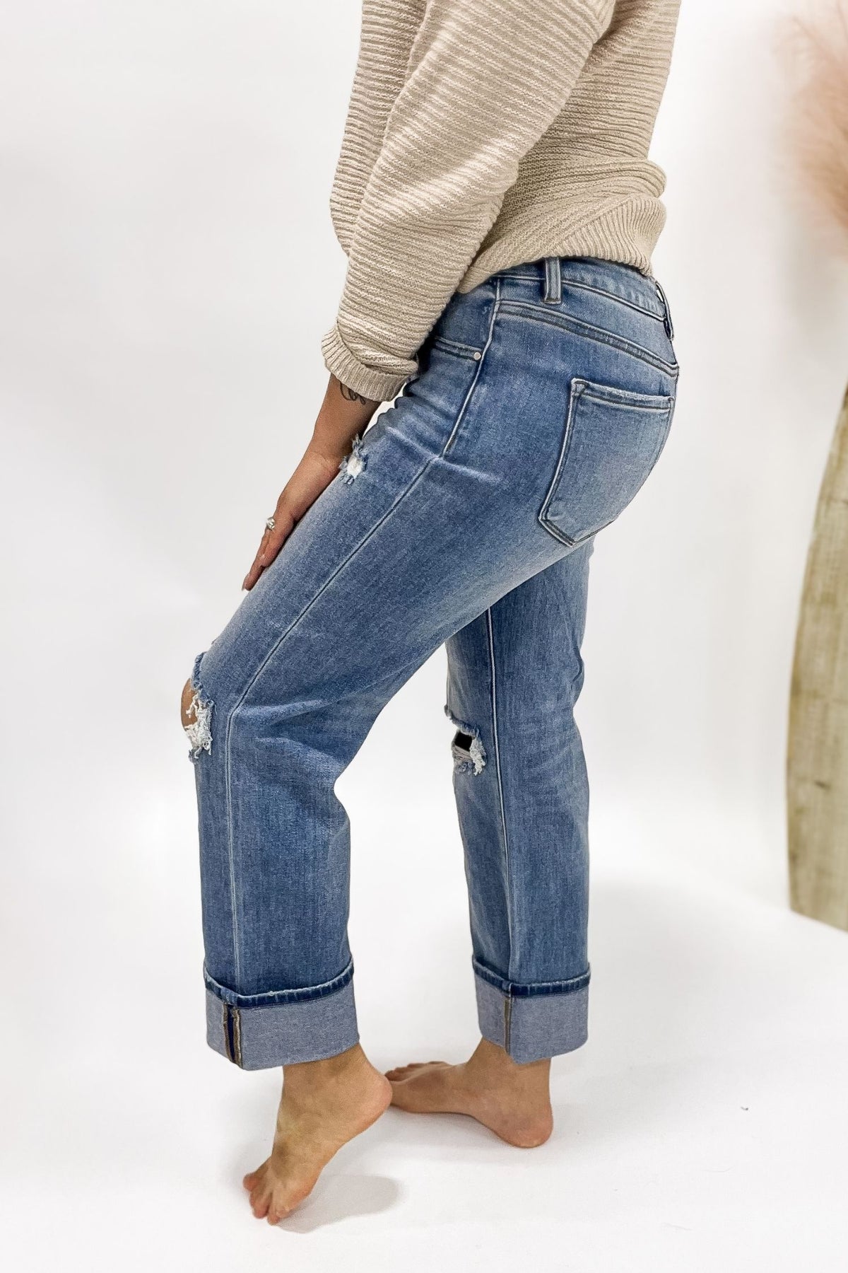 Person wearing blue jeans with a neutral background