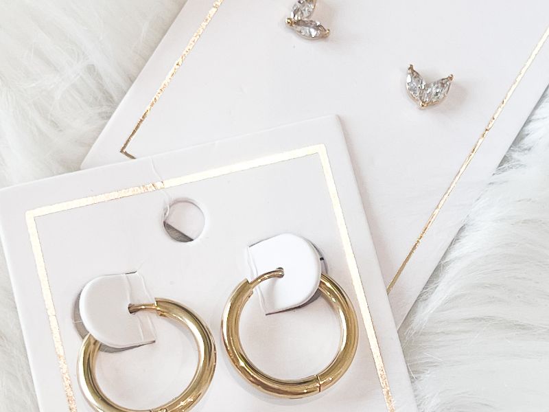 Gold hoop earrings on a white card with a soft white background. Shop our accessories collection to find, hair claws, more earring styles, handbags, lip balm and more!