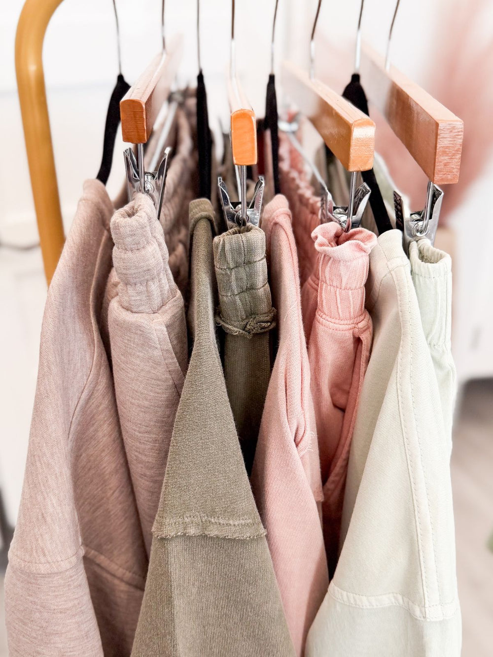 Clothing items on hangers with wooden clips in a closet.