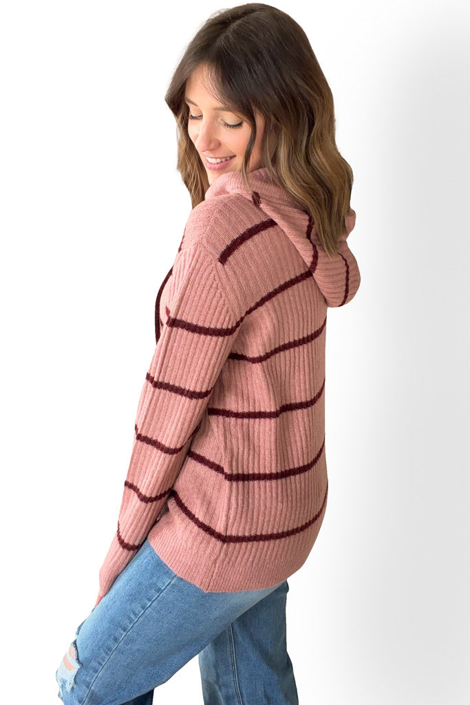 Woman wearing a mauve striped sweater on a white background