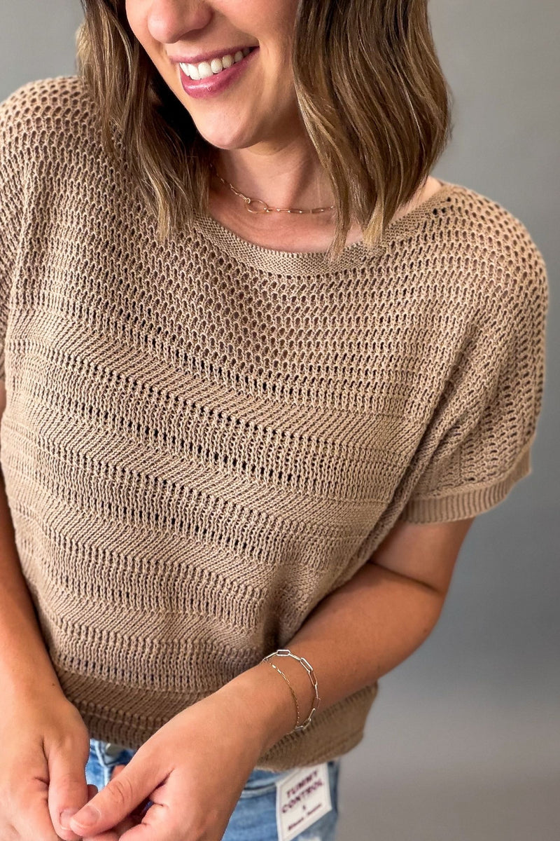 close up of a woman wearing a mocha crew neck short sleeve pointelle short sleeve sweater