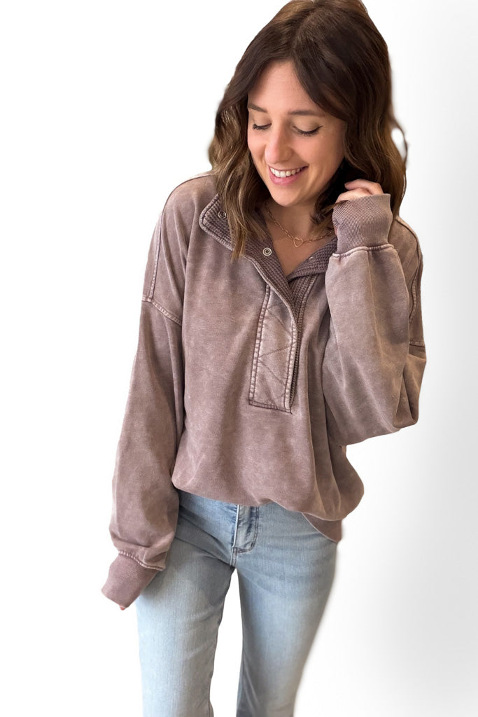 Woman wearing a mocha pullover with a white background