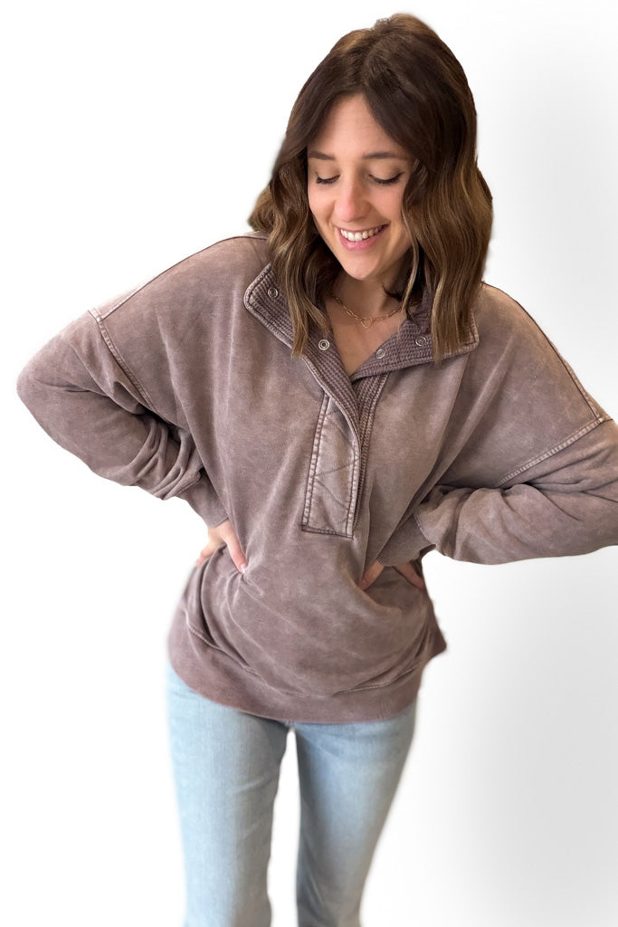 Woman wearing a mocha  pullover with a white background