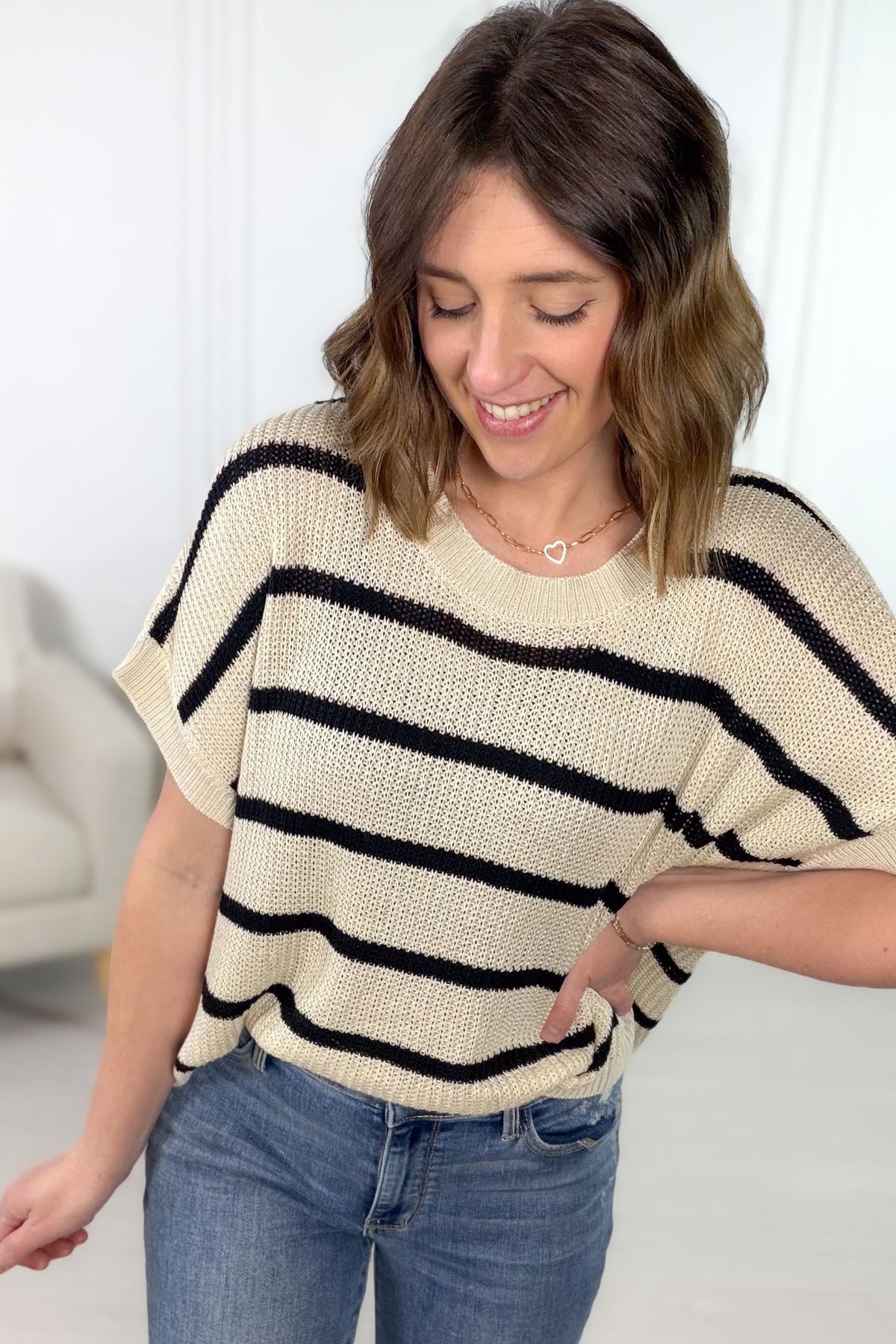 Natural and black striped relaxed fit short sleeve sweater with lightweight open knit texture styled with denim.