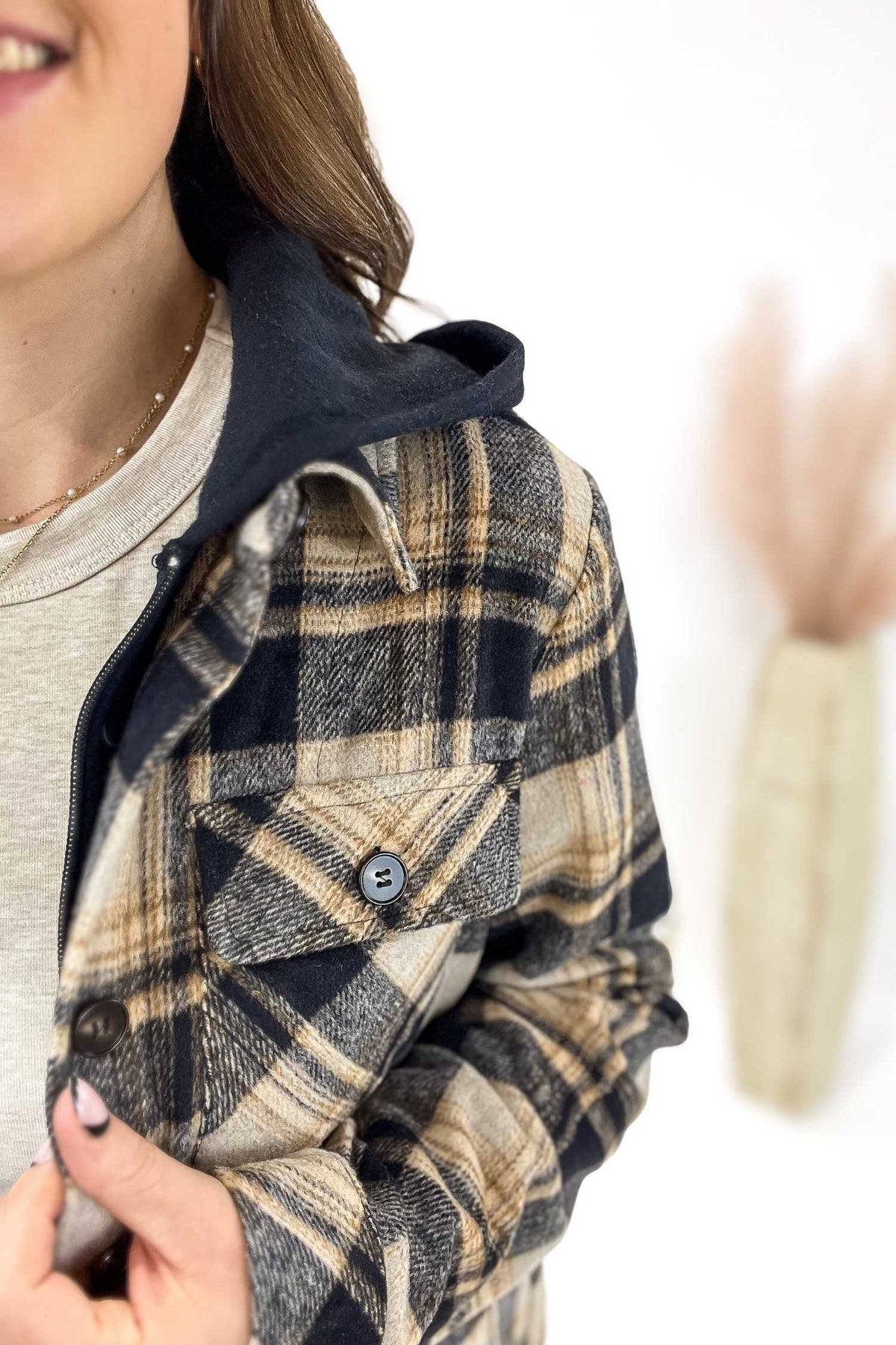 Plaid jacket with a button detail on a white background