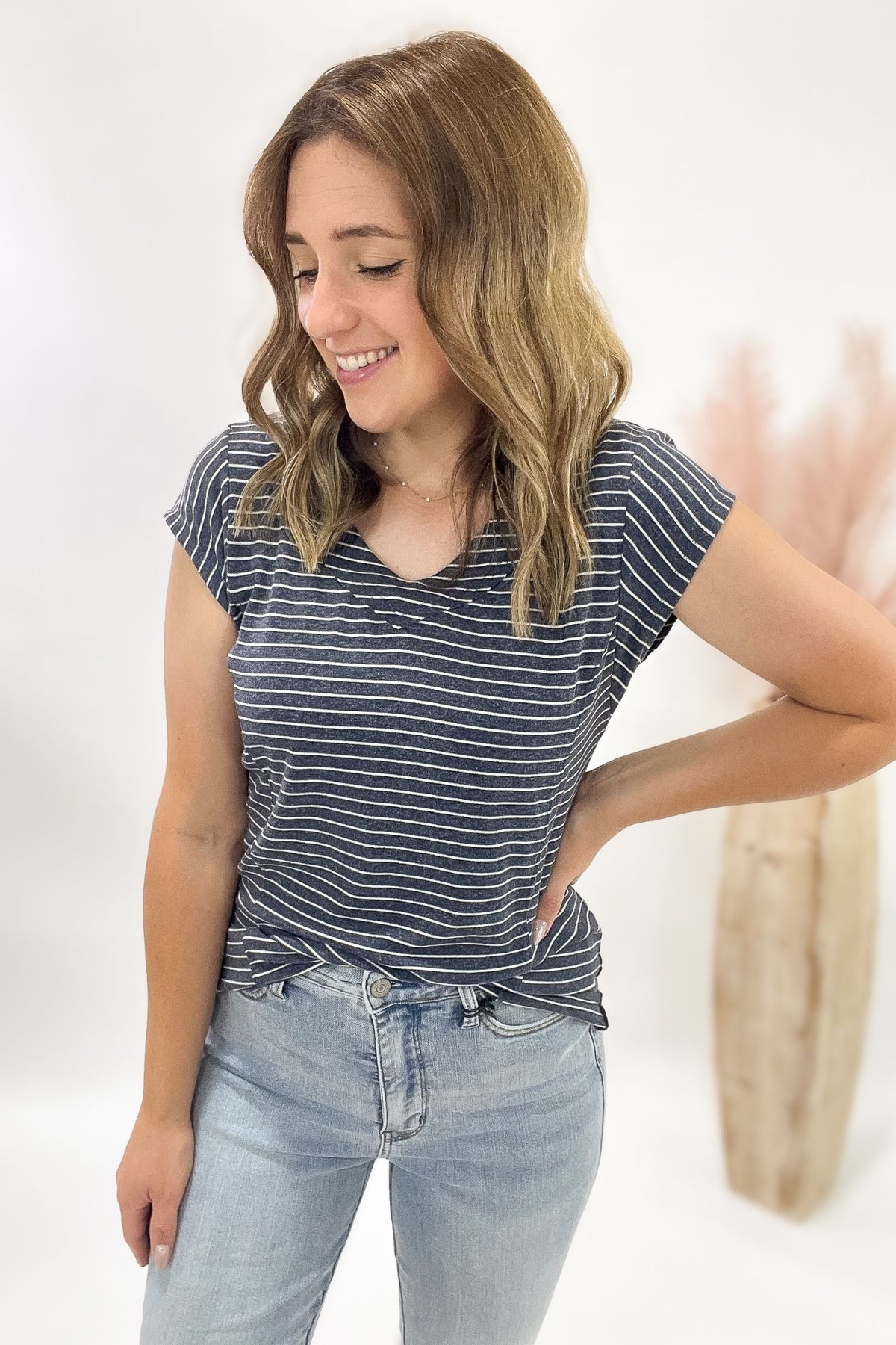 Woman wearing a striped shirt and jeans against a white background