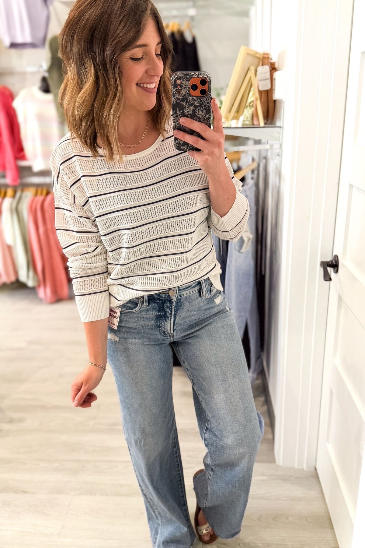 woman taking a selfie wearing a light weight textured long sleeve with navy stripes and white texture.