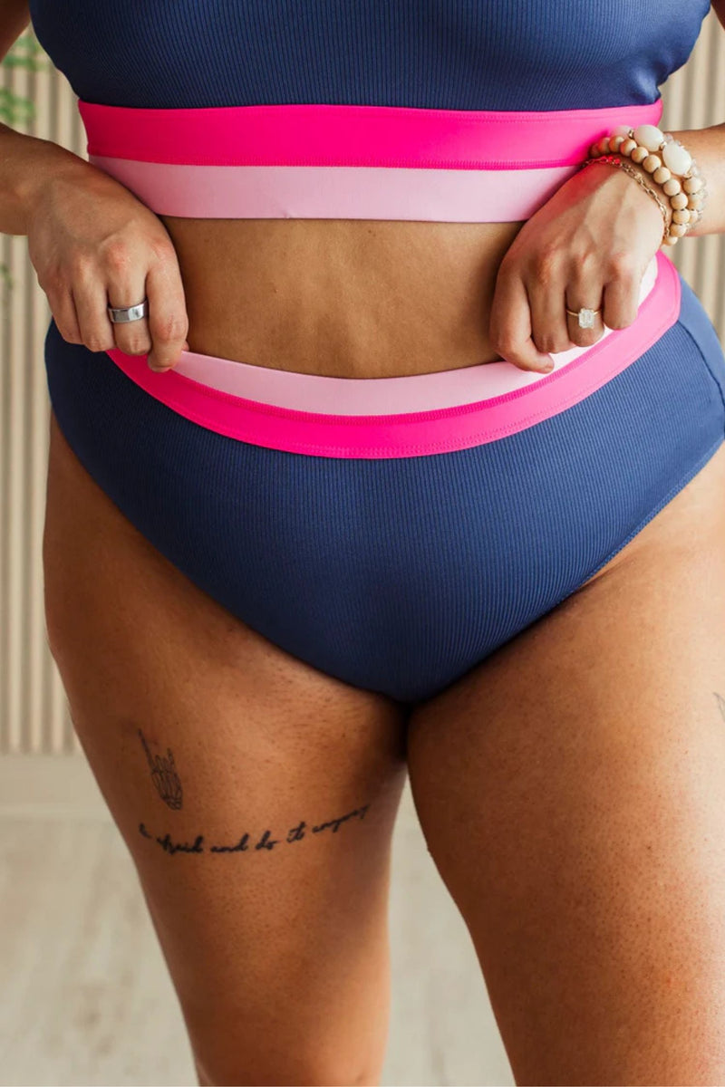 Navy ribbed high rise swim bottoms with pink and blush waistband detail.