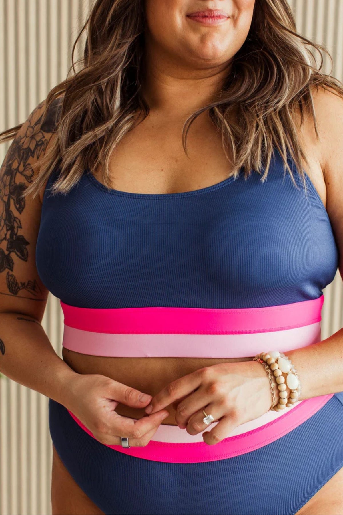 Navy ribbed swim top with pink and blush elastic band and adjustable straps.