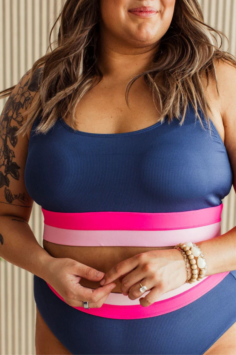 Navy ribbed swim top with pink and blush elastic band and adjustable straps.